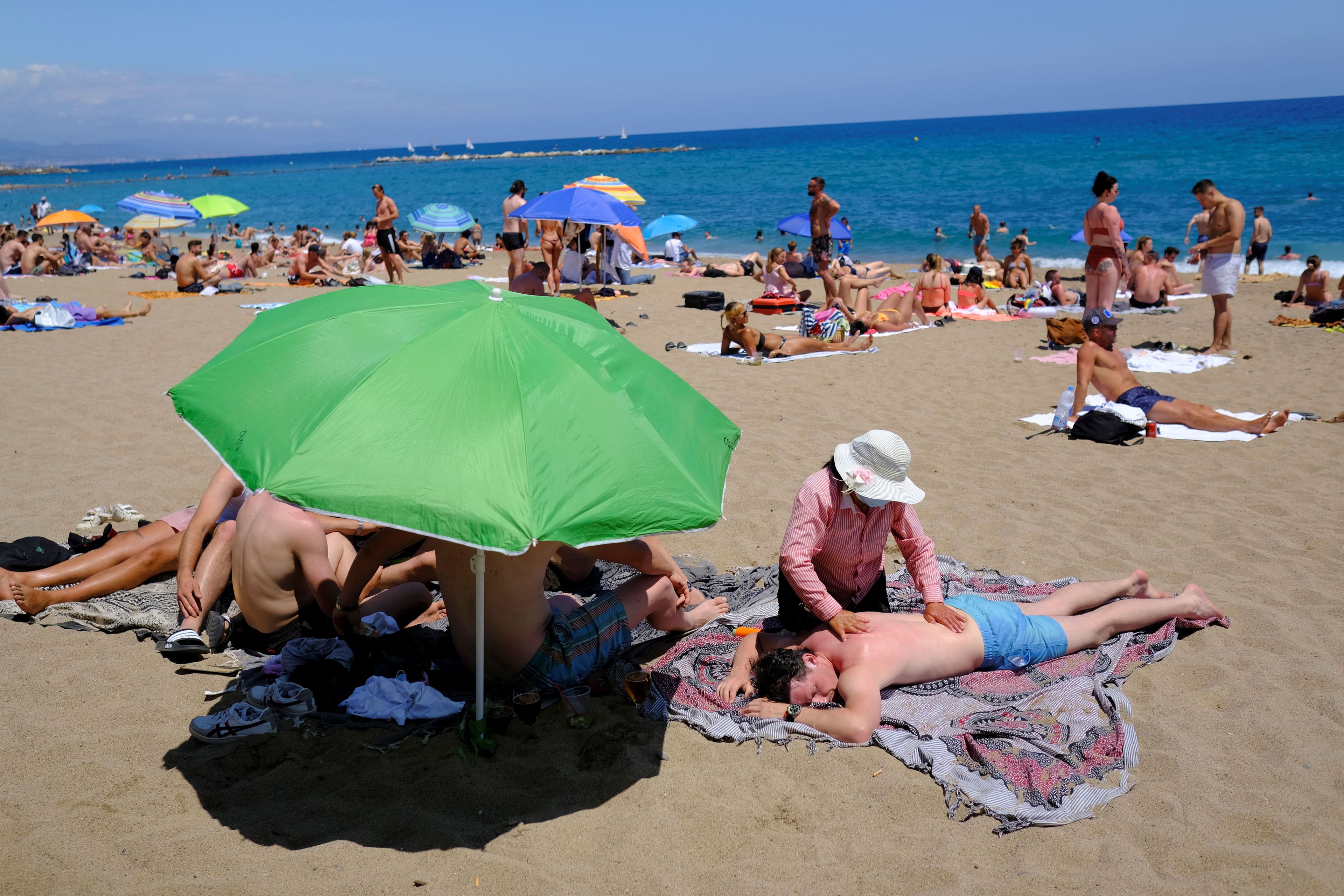 Un hombre recibe un masaje en la playa