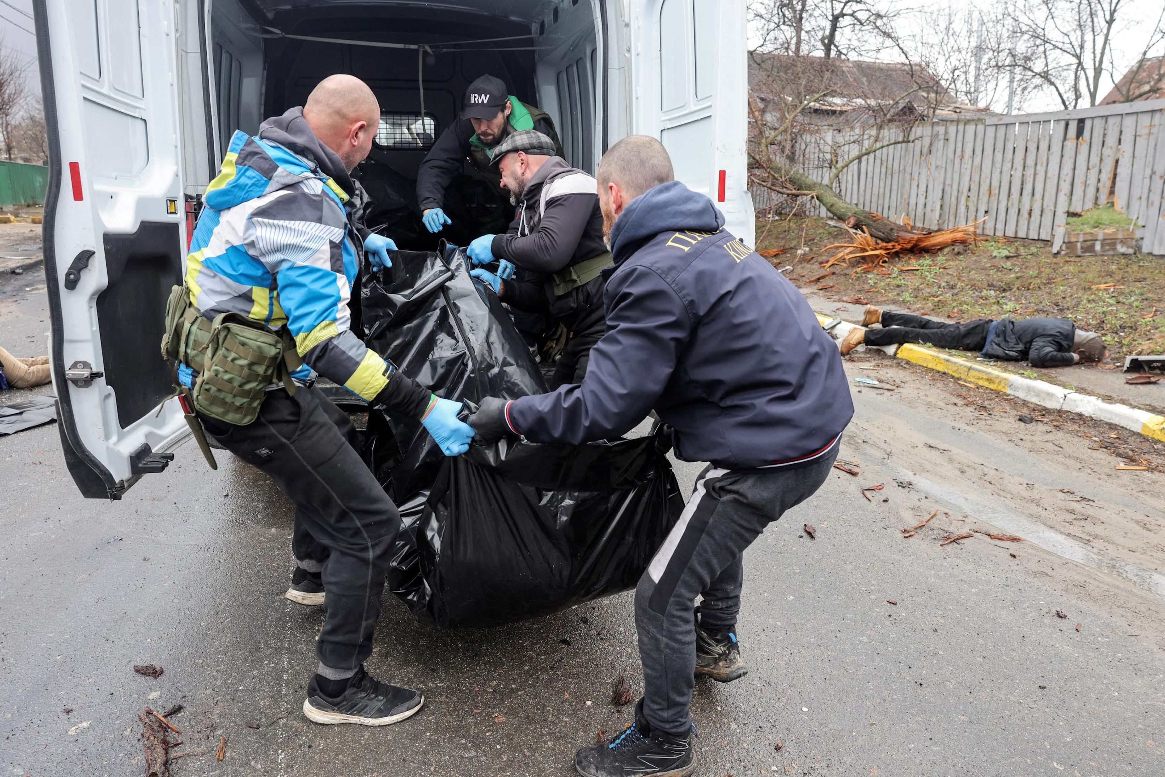 Voluntarios cargan en una furgoneta el cuerpo de un civil, que según los residentes fue asesinado por soldados rusos, en medio de la invasión rusa a Ucrania, en Bucha.