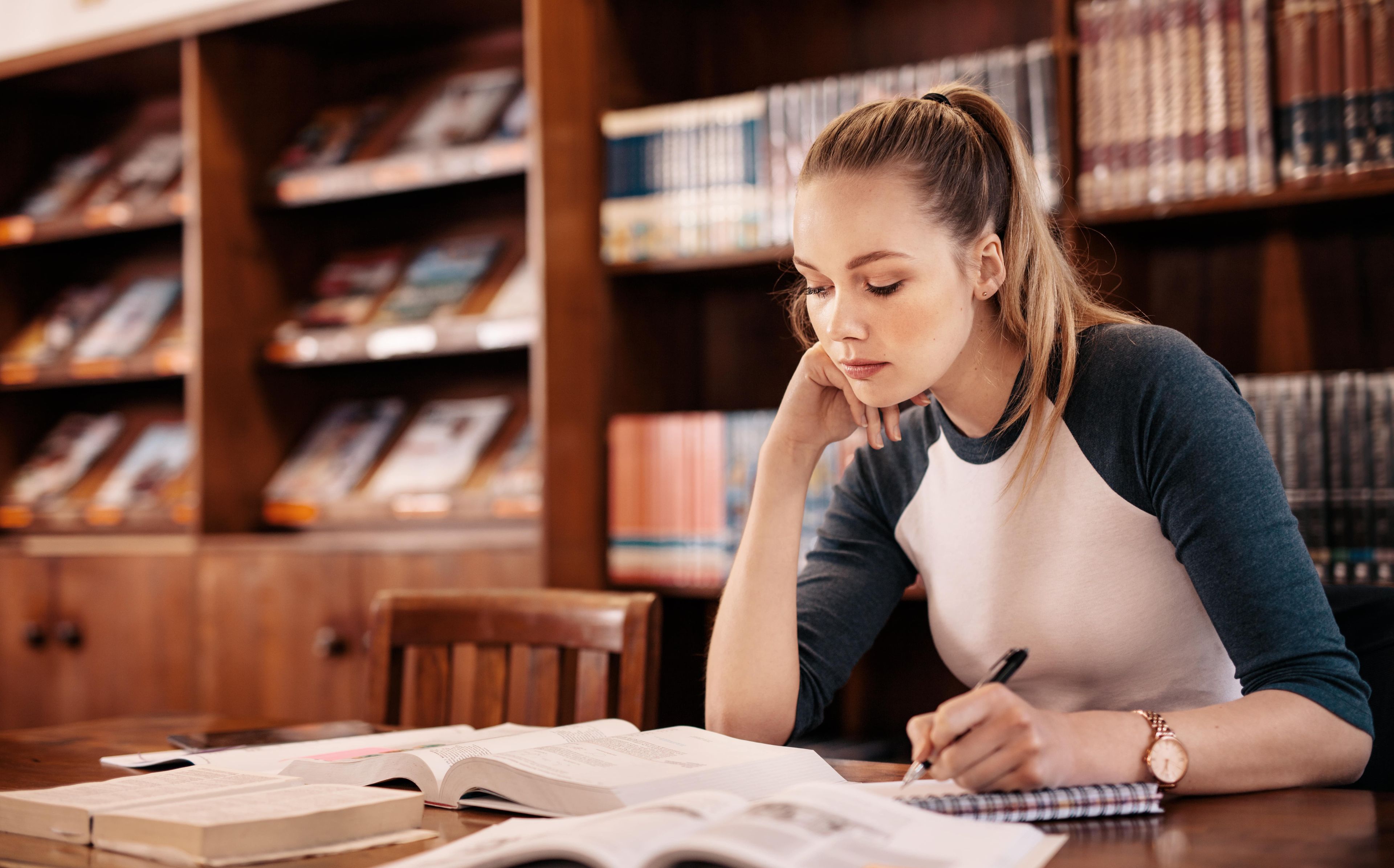 Una mujer estudia en una biblioteca