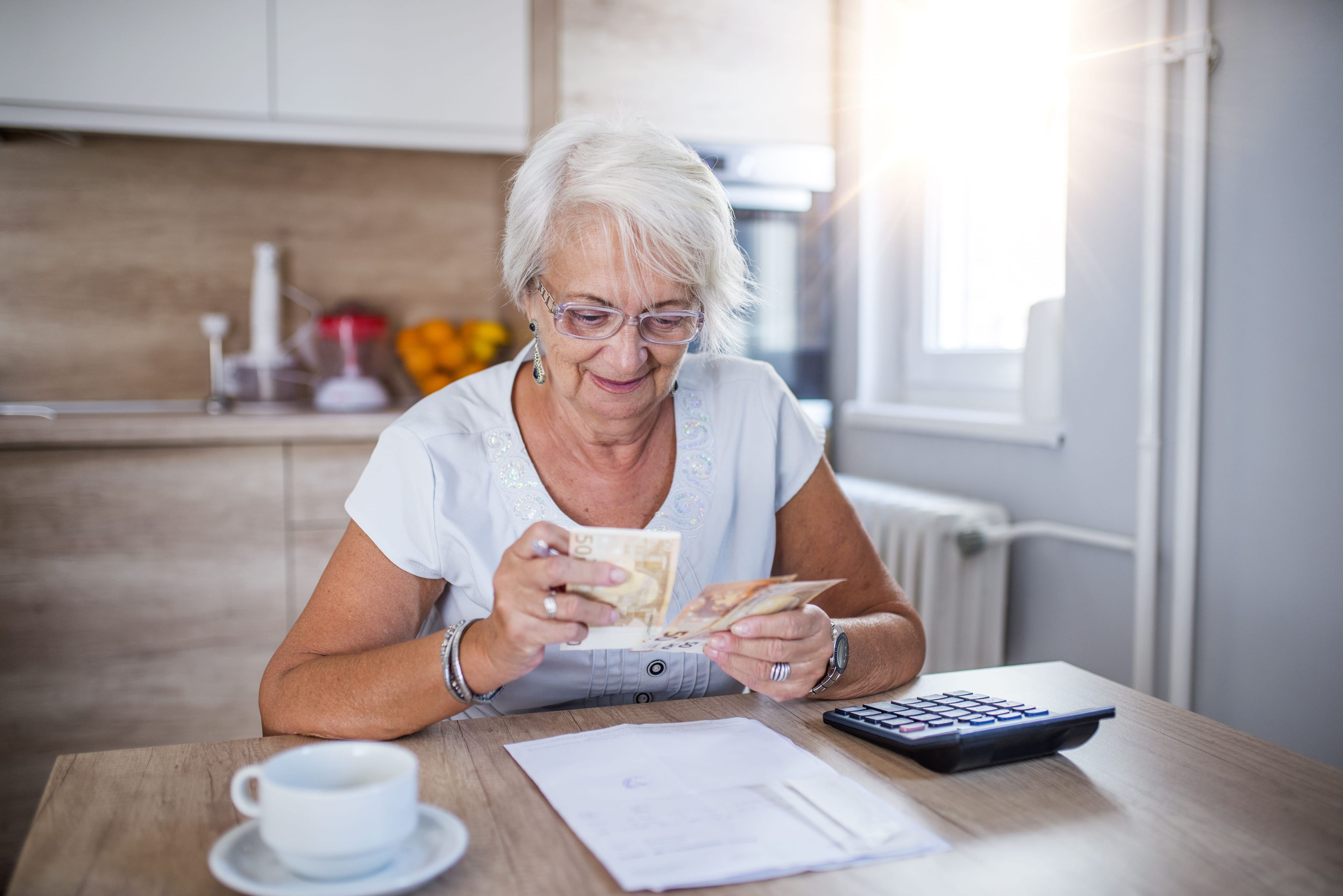 Mujer mayor cuenta su dinero