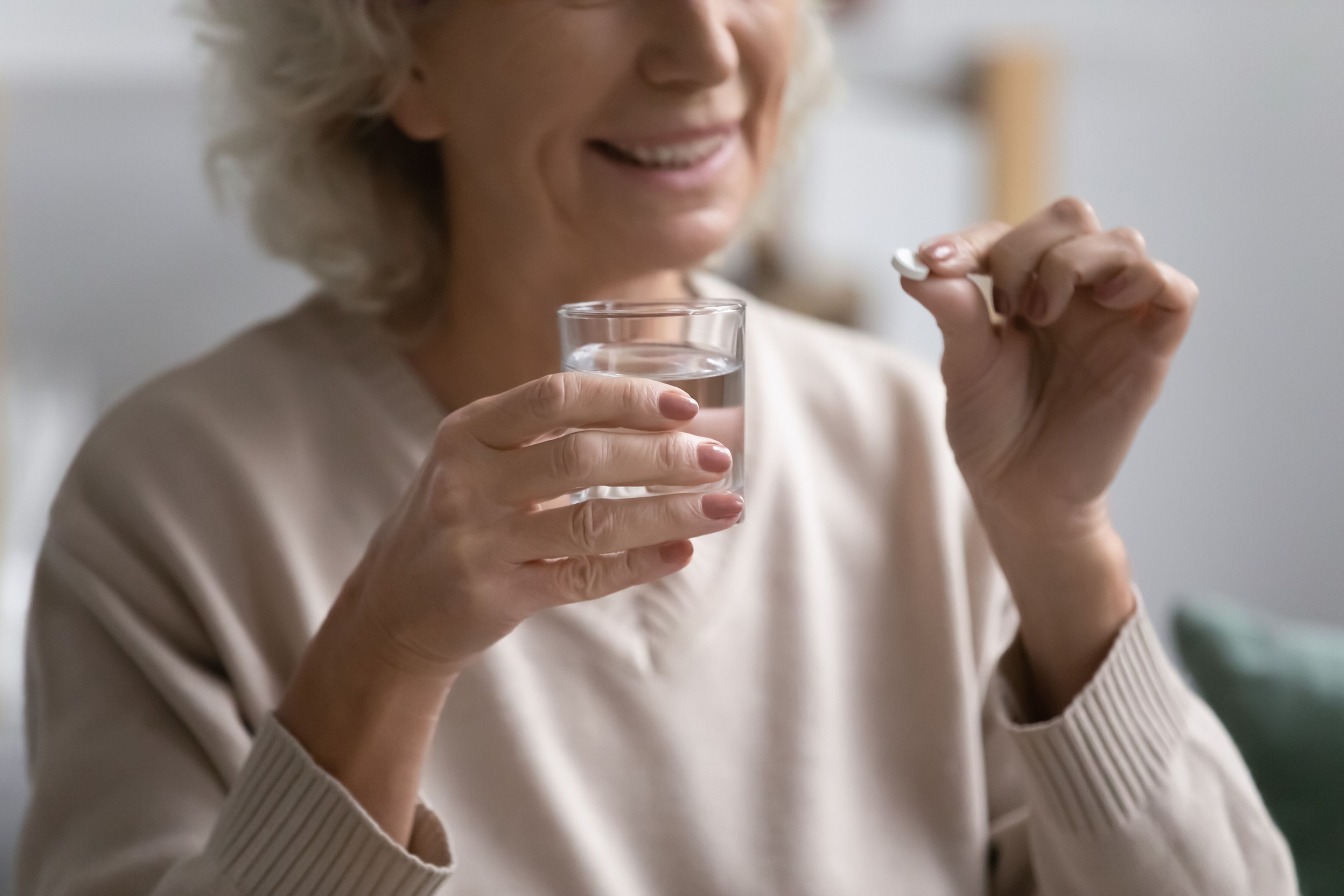 Mujer mayor tomando una pastilla