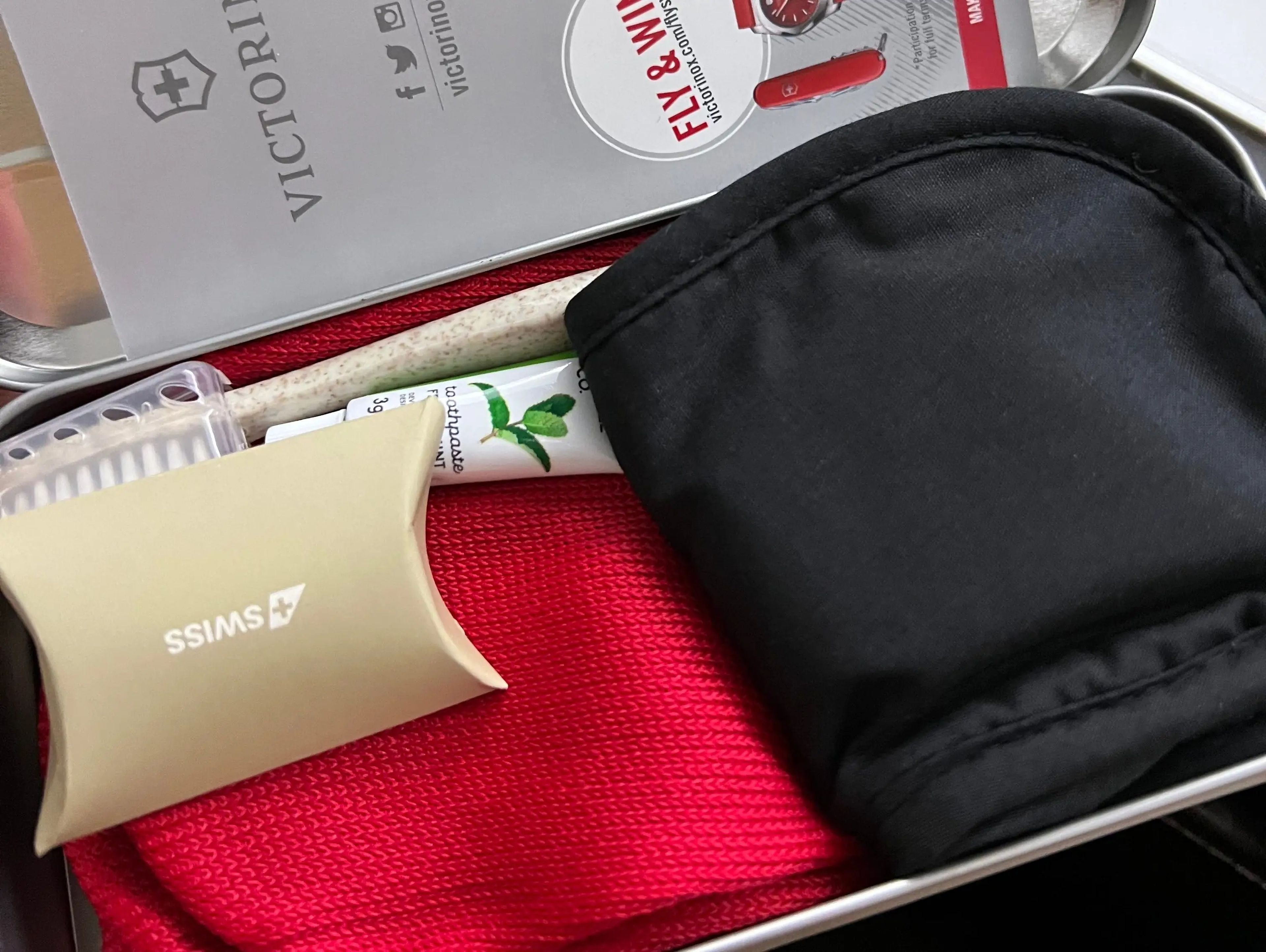an amenity kit on a plane filled with some basic skincare, socks, and eye mask
