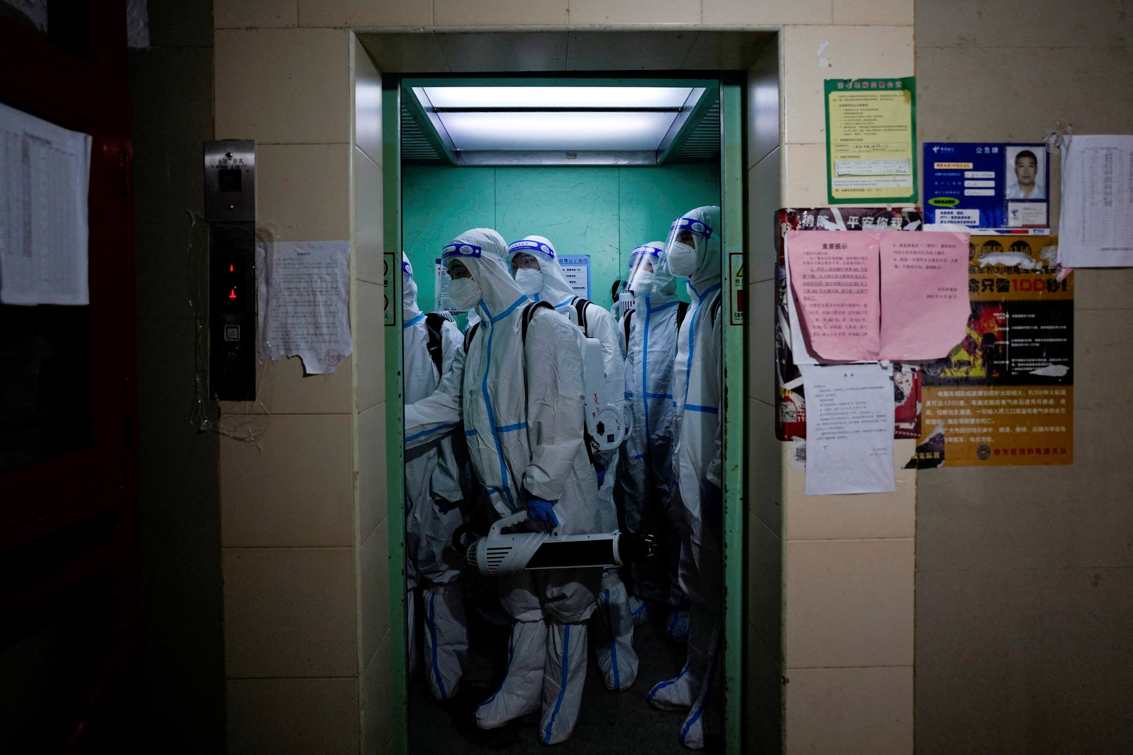 Un equipo de sanitarios vestidos con trajes de protección contra el COVID-19 desinfectan un área residencial de Shanghái (China), confinada por el aumento de positivos.