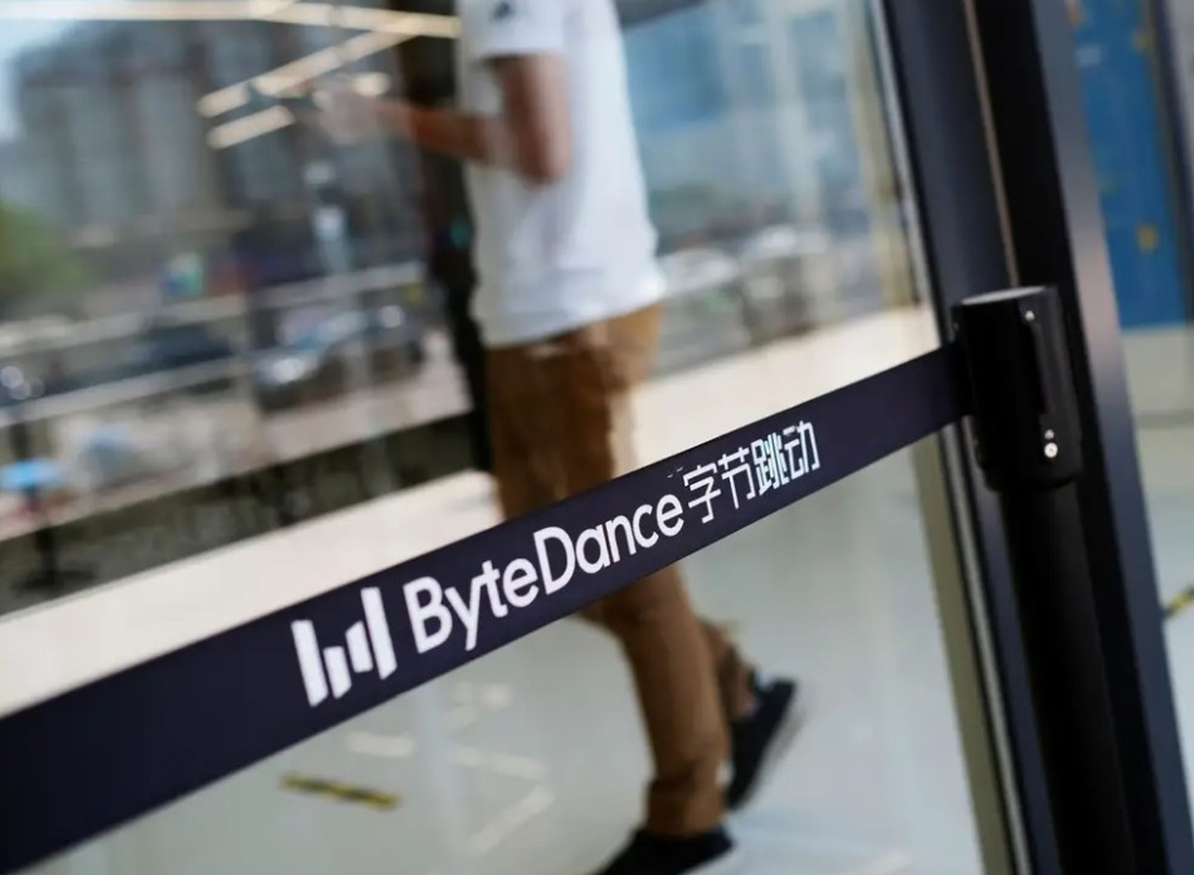 Un hombre camina junto a un logotipo de Bytedance, la empresa con sede en China propietaria de la aplicación de vídeos cortos TikTok, o Douyin, en su oficina de Pekín, China, el 7 de julio de 2020.