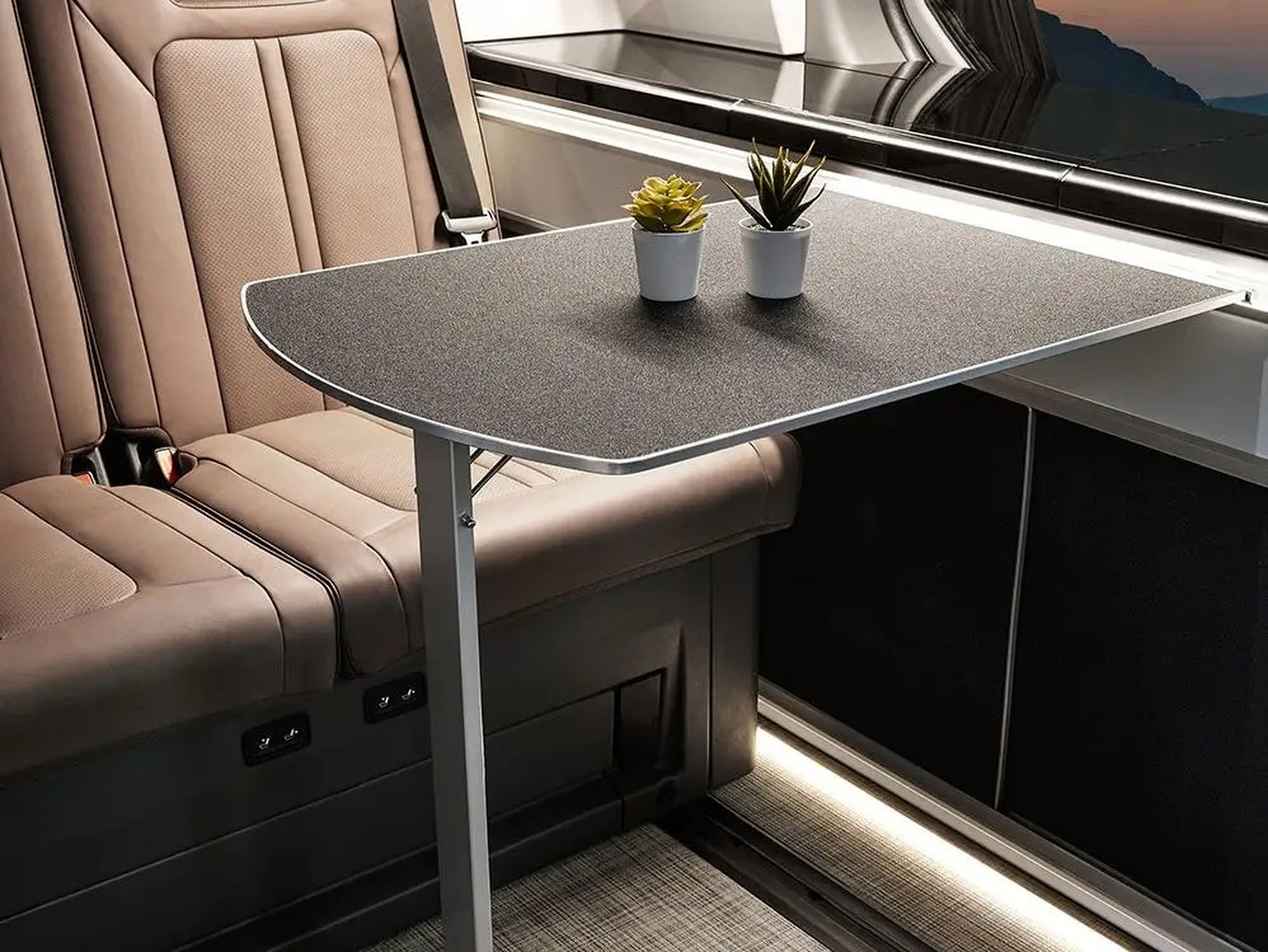 The Hyundai Staria Lounge Camper's interior table next to brown seats.