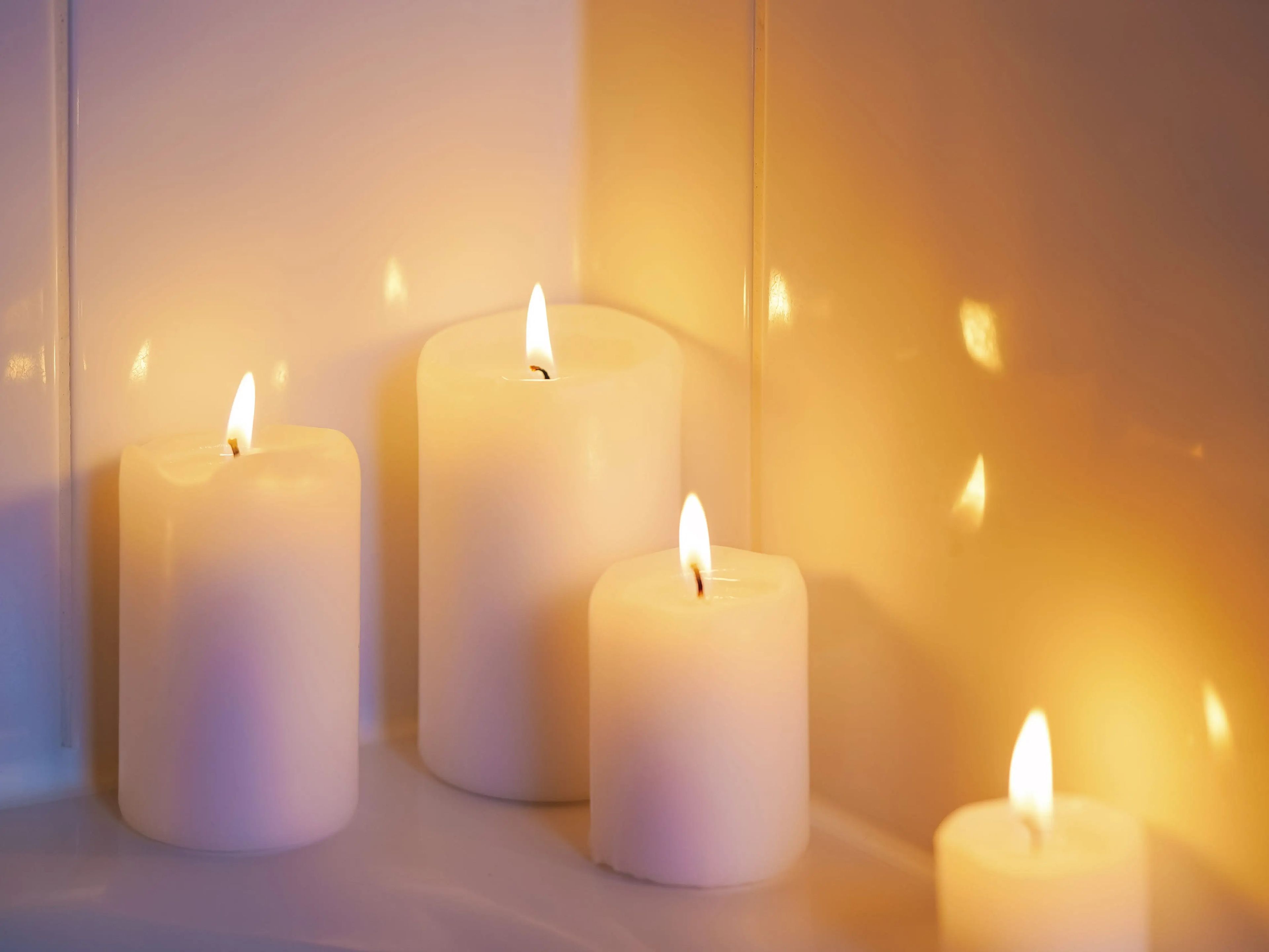 lit, white candles arranged on corner of tub