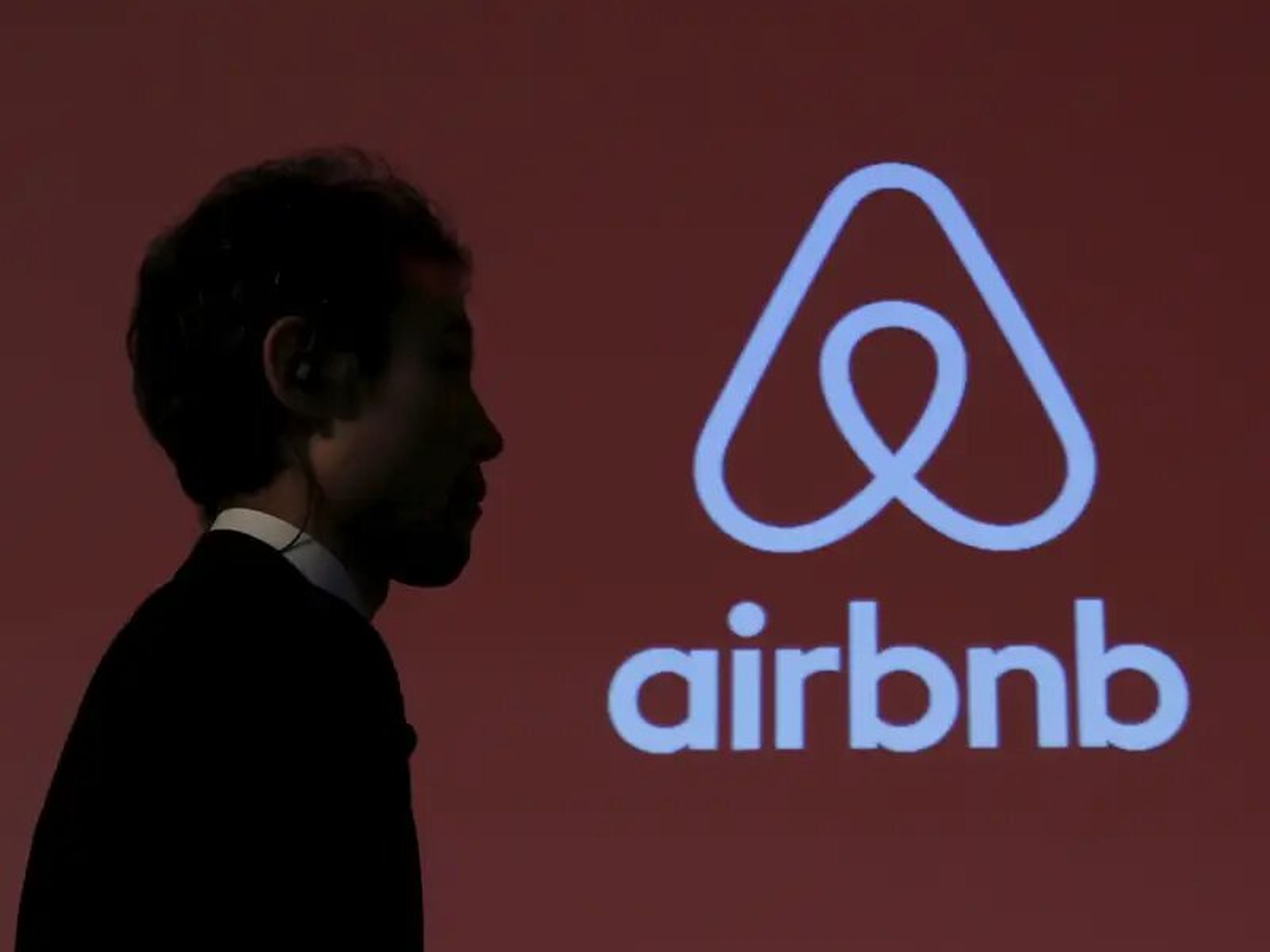 Un hombre pasa por delante de un logotipo de Airbnb tras una conferencia de prensa en Tokio, Japón, el 26 de noviembre de 2015.
