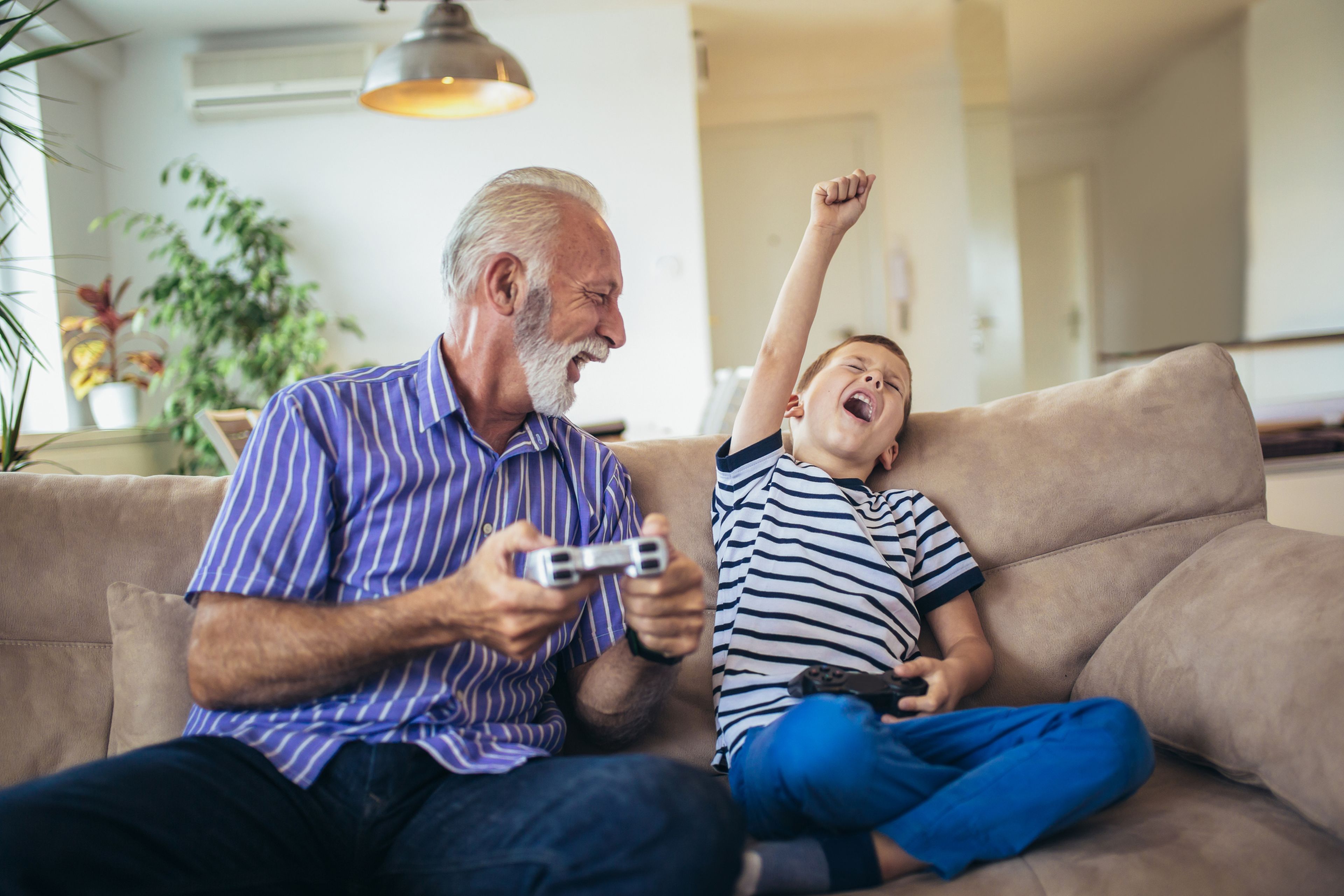Niño con su abuelo jugando videojuegos
