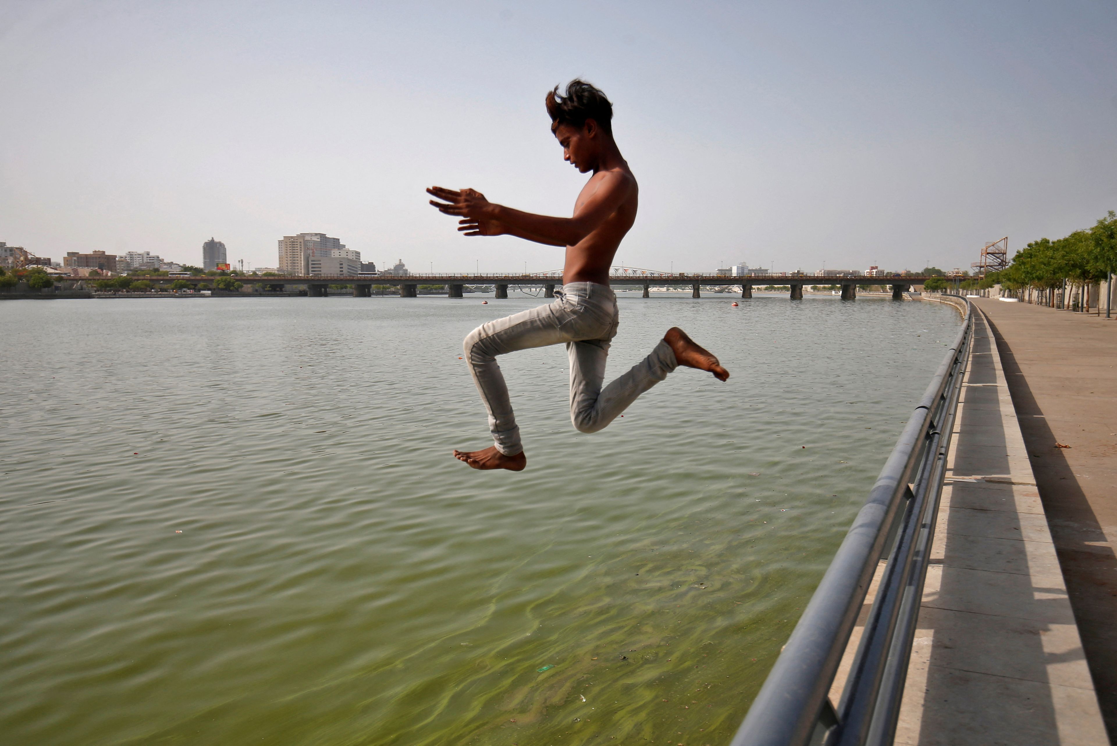 Niño salta al río Sabarmati para refrescarse durante la ola de calor en Ahmedabad (India) el 7 de mayo de 2022.