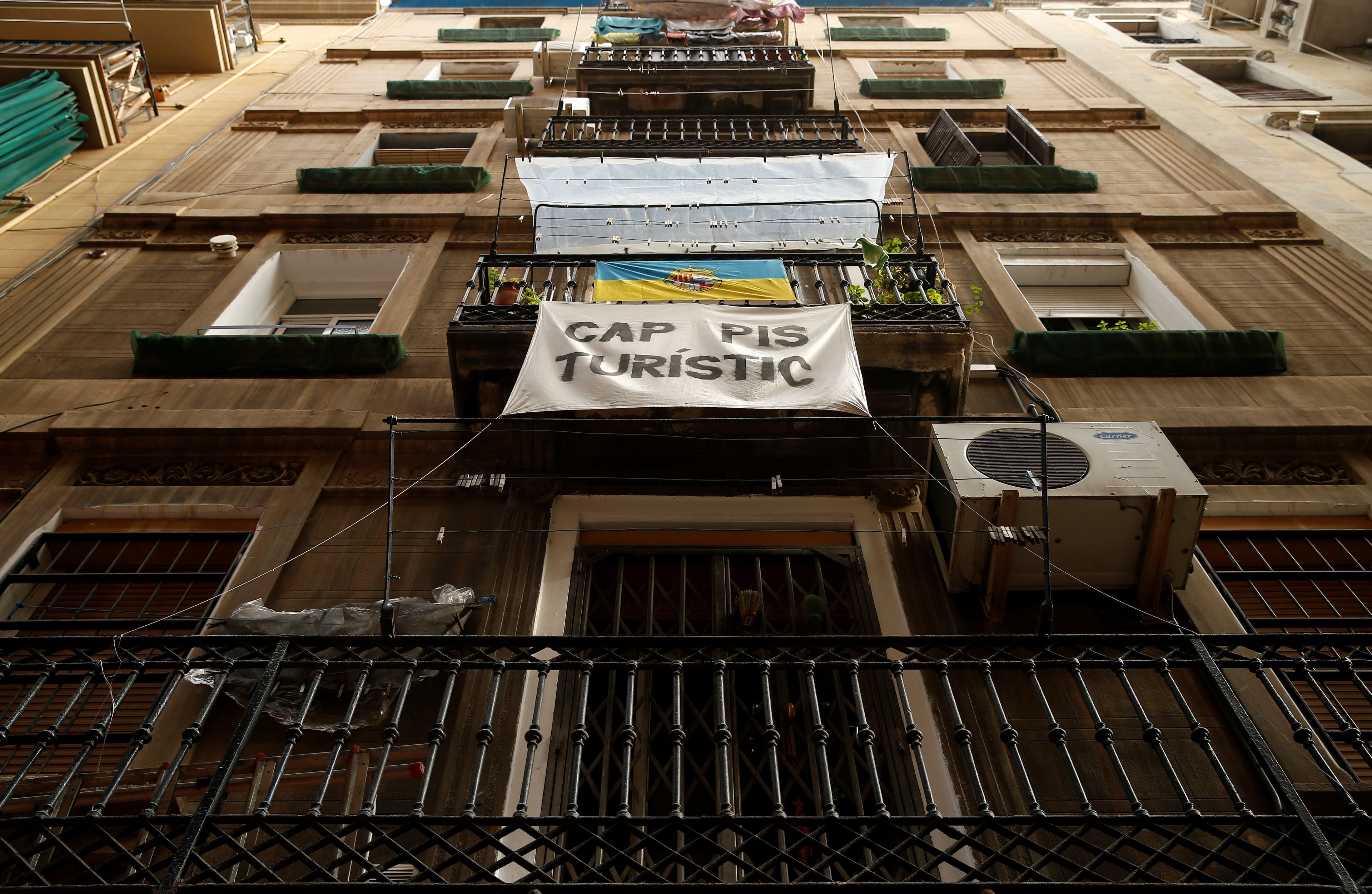 Una pancarta contra los apartamentos para turistas cuelga de un balcón en el barrio de la Barceloneta en Barcelona.