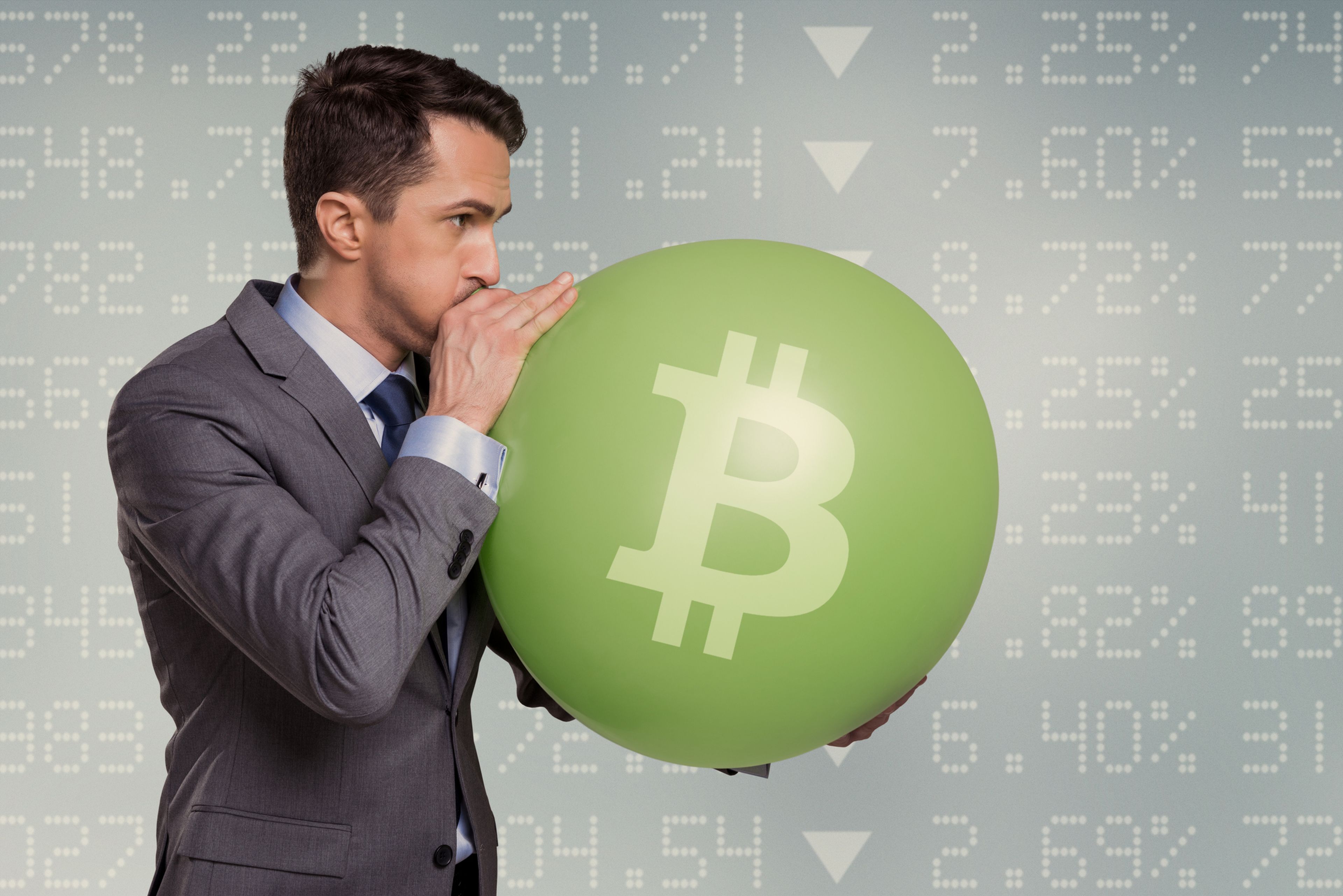 Una persona infla un globo con el símbolo de bitcoin.
