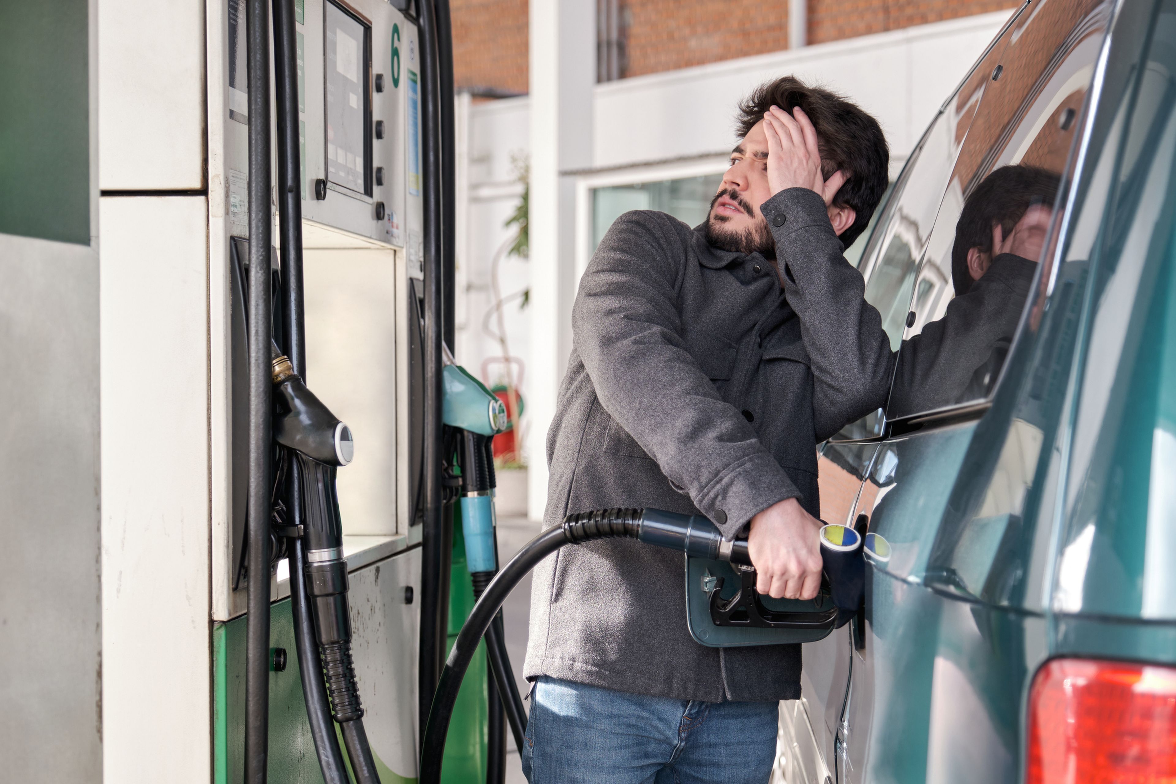 Una persona se lleva las manos a la cabeza al ver el precio de la gasolina.