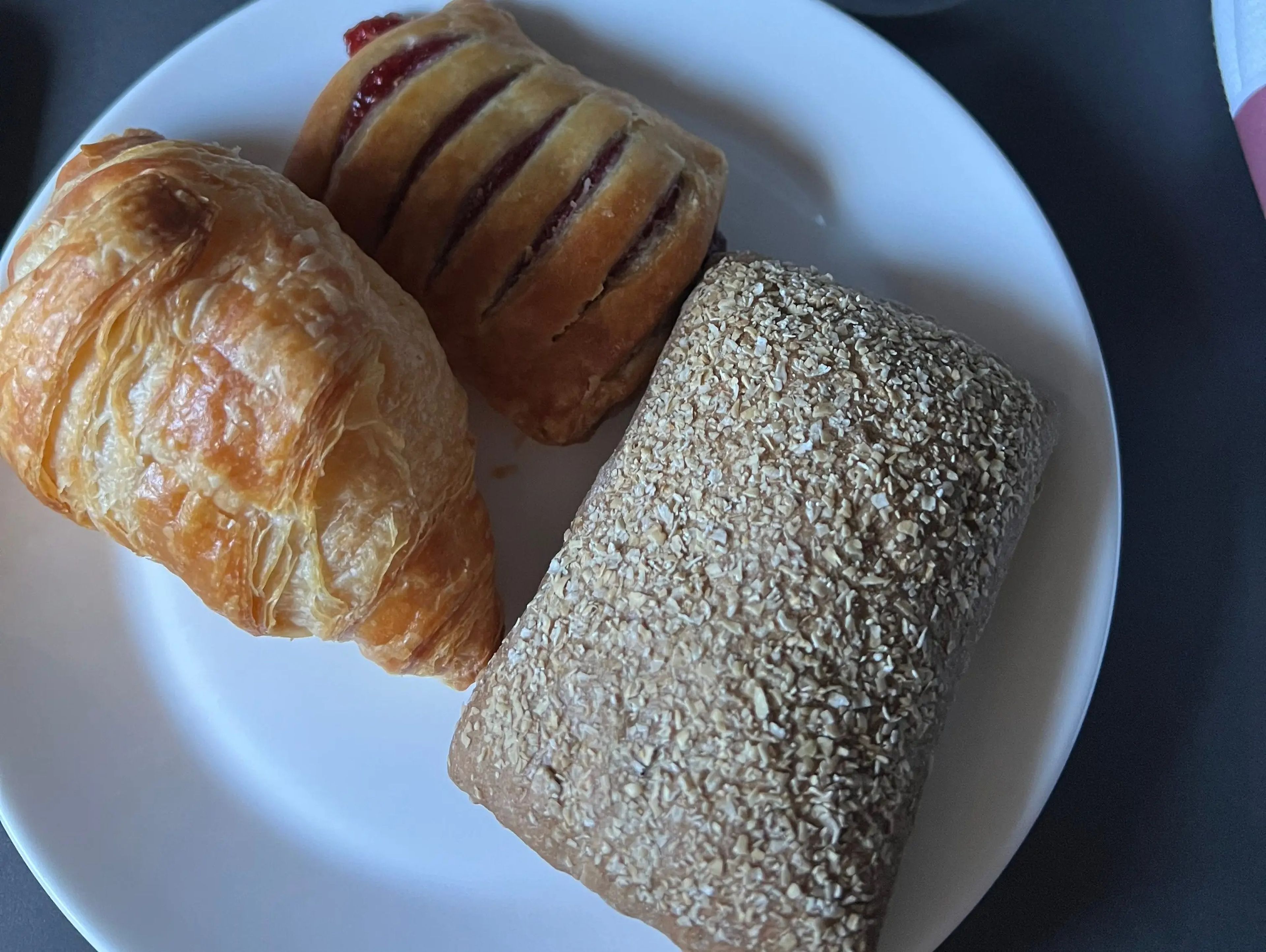 a plate with three pastries on it on the plane