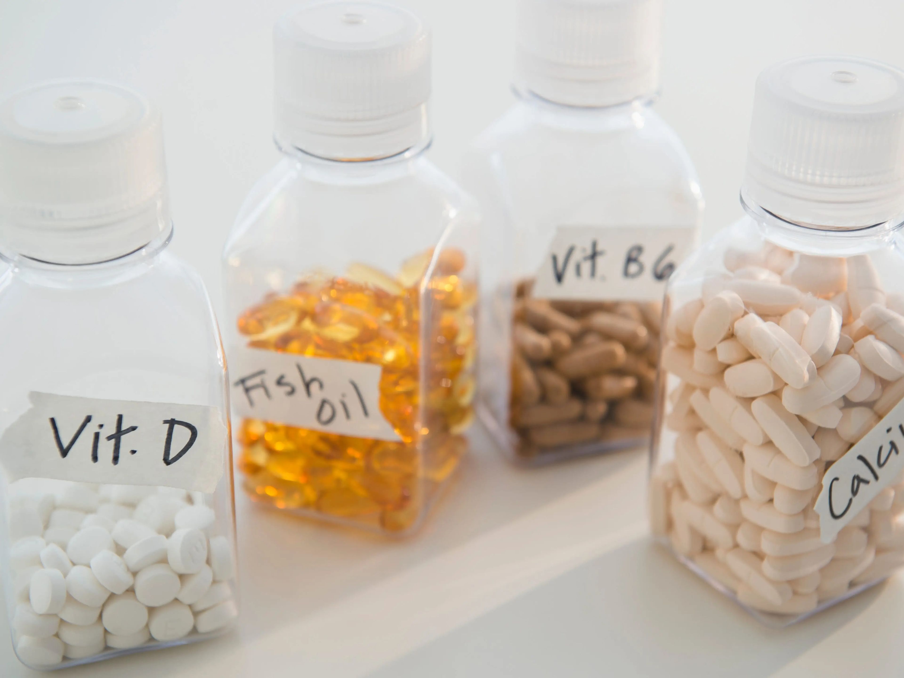 vitamin d, fish oil, vitamin b6, and calcium supplement bottles stand next to each other on a table