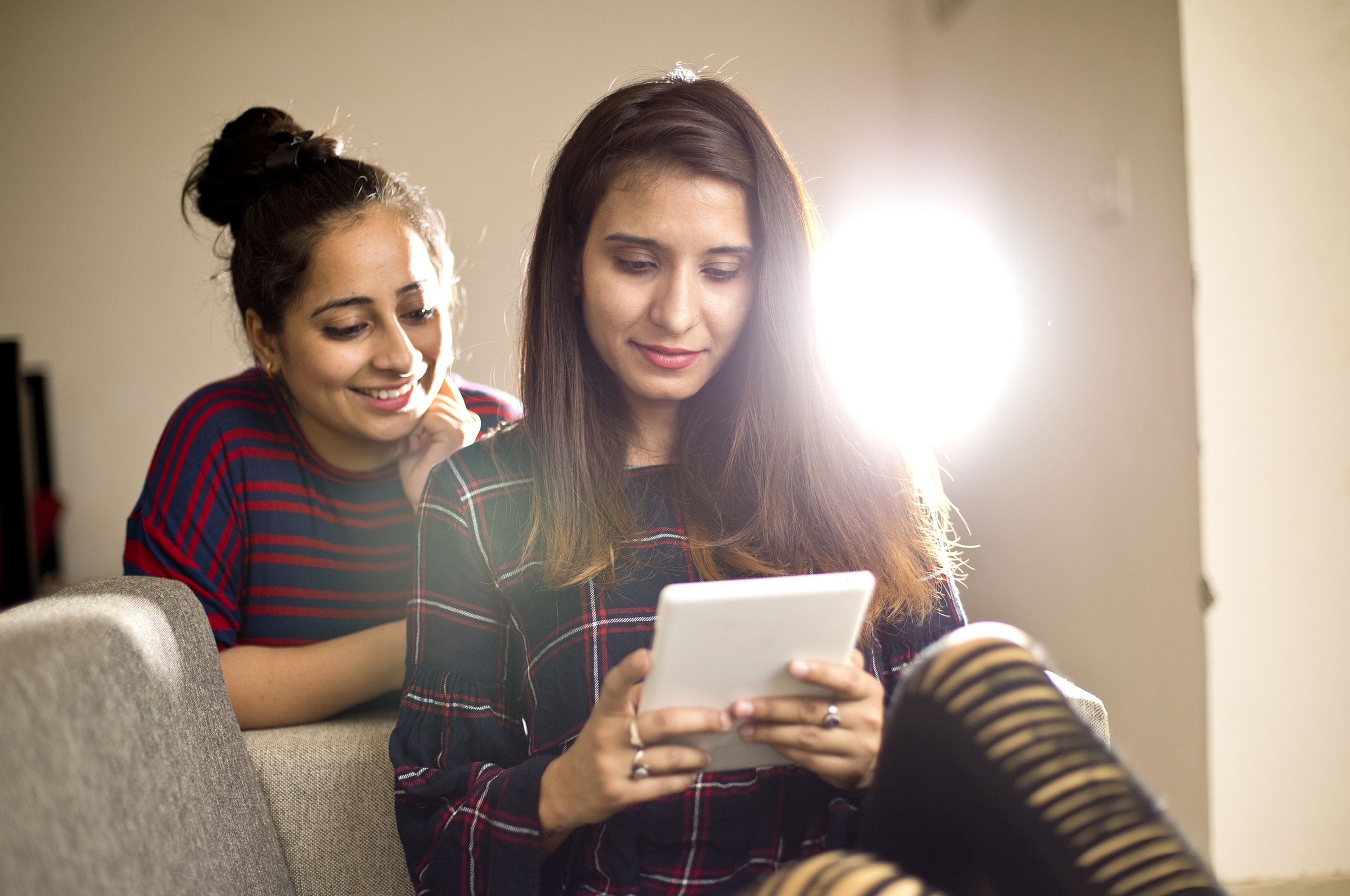 2 mujeres miran una tablet.
