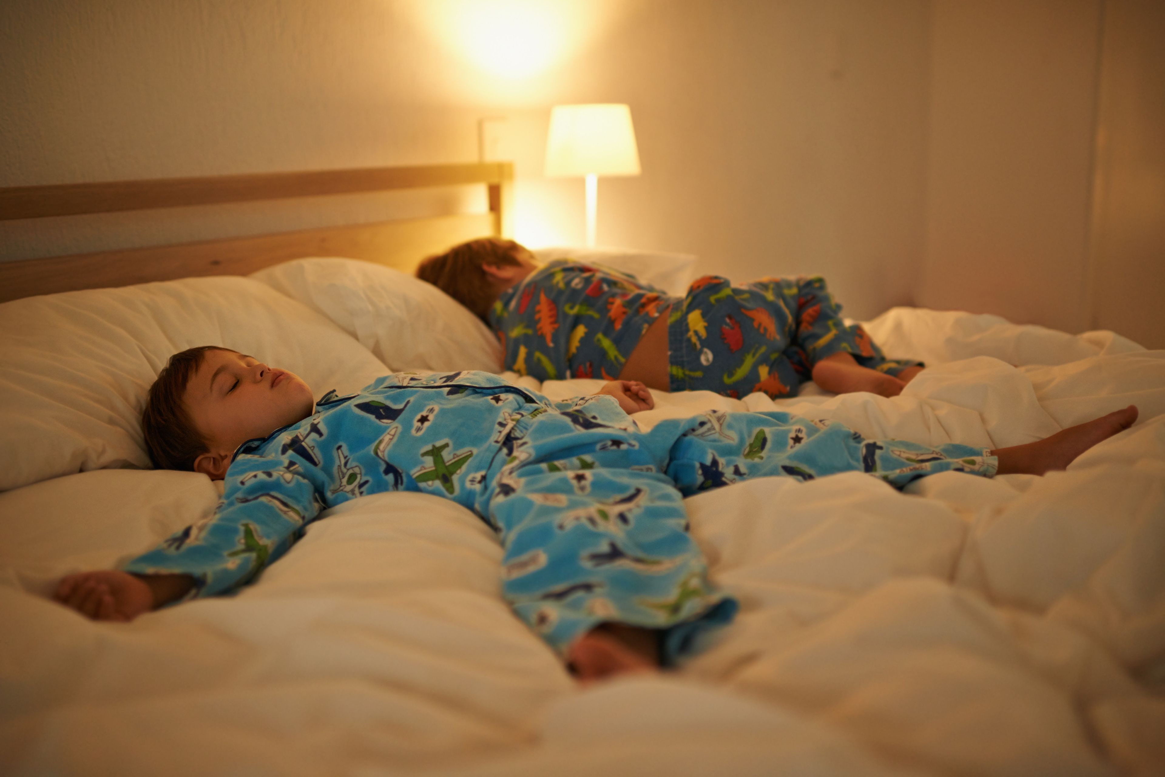 2 niños duermen en la cama.