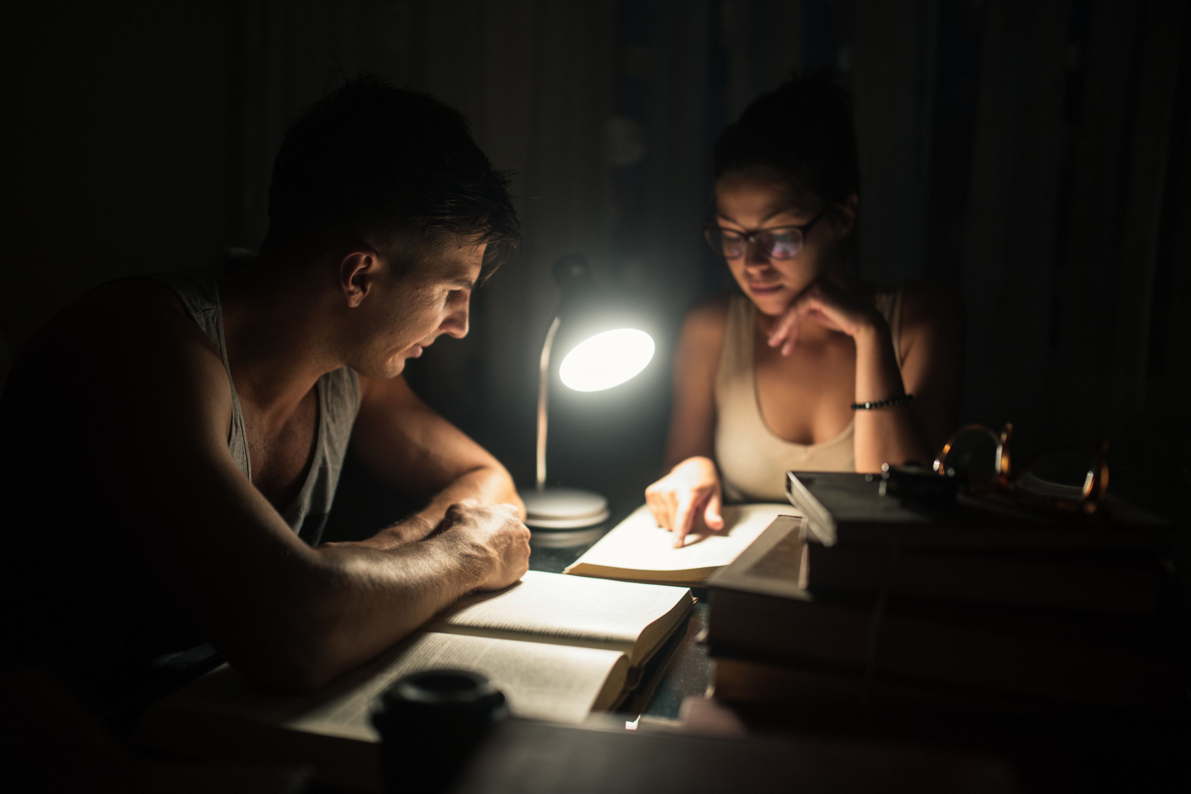2 personas estudian por la noche.