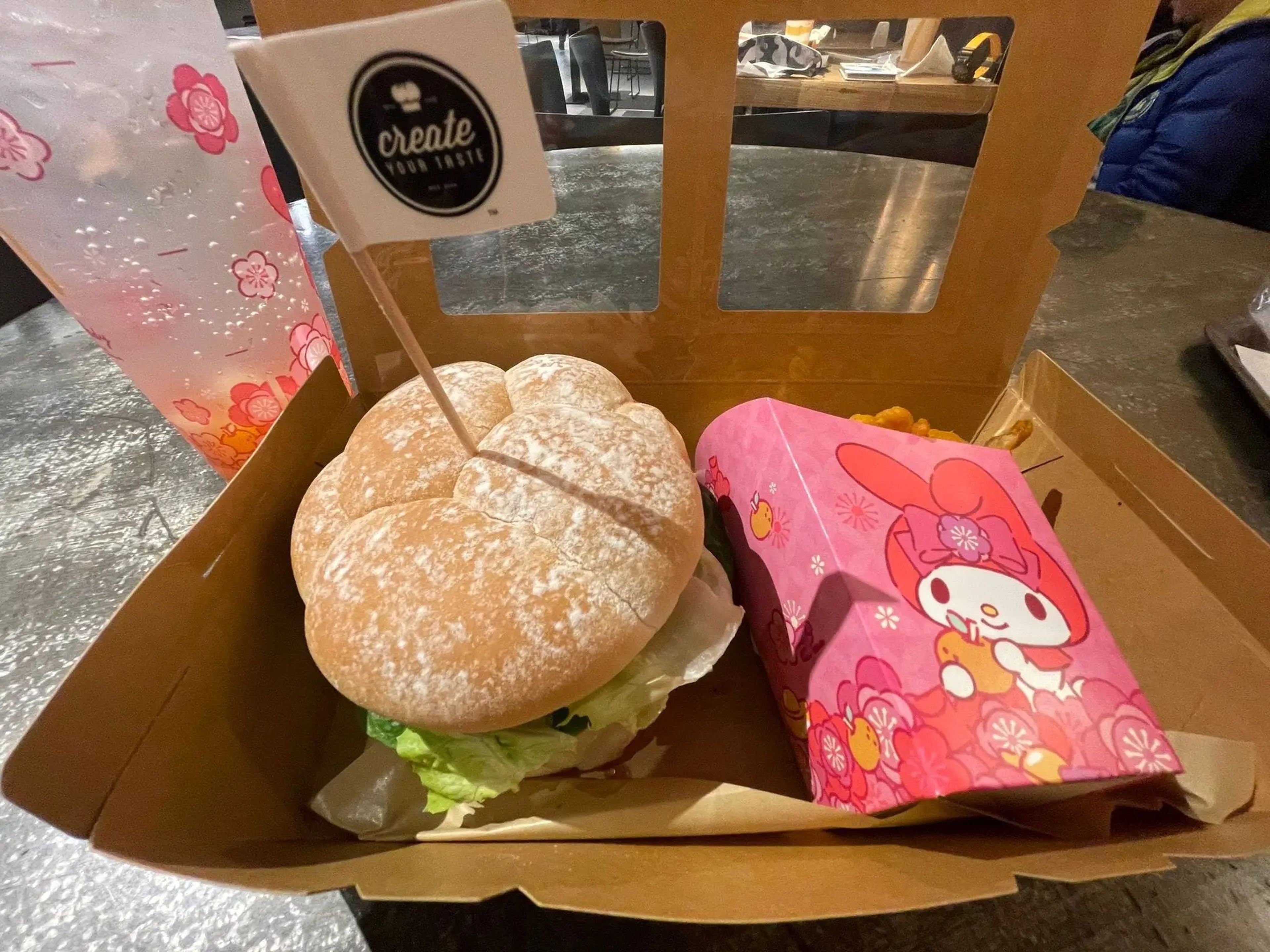 Close up of burger with brioche bun and container of curly fries with cartoon rabbit on it