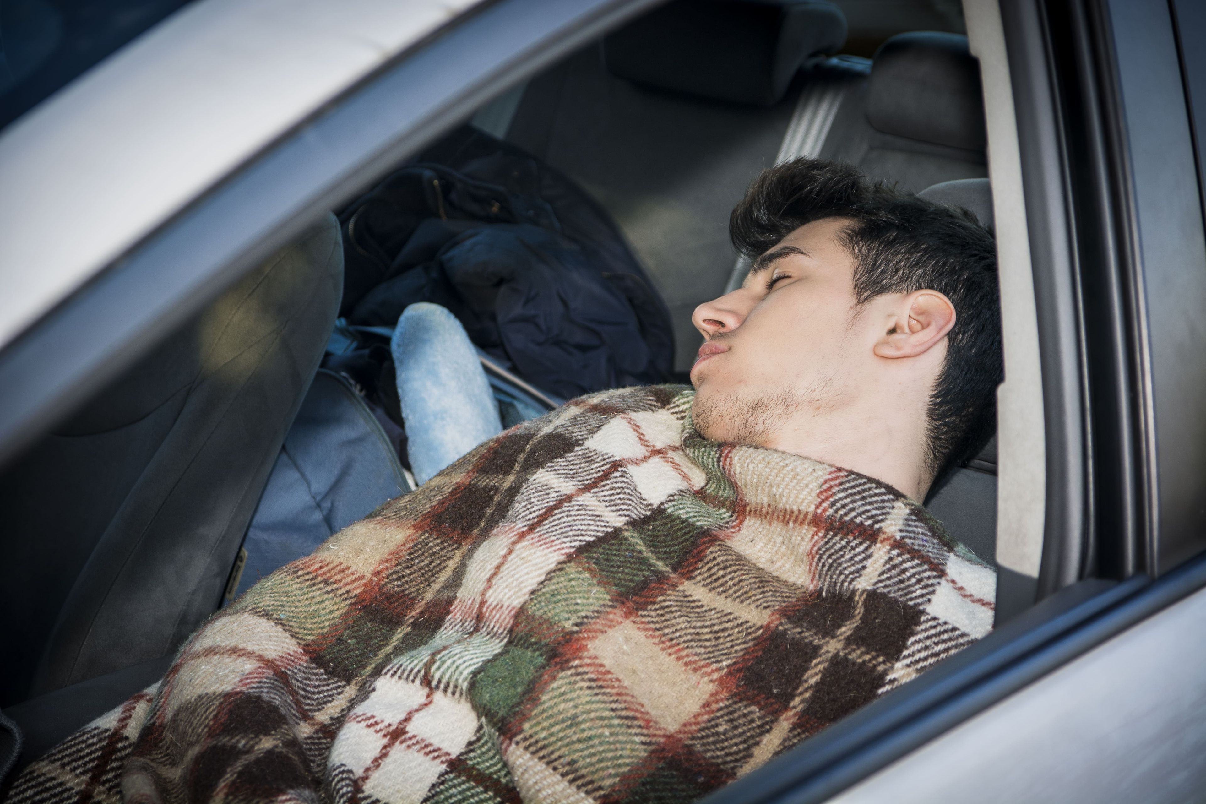 Un hombre durmiendo en el coche