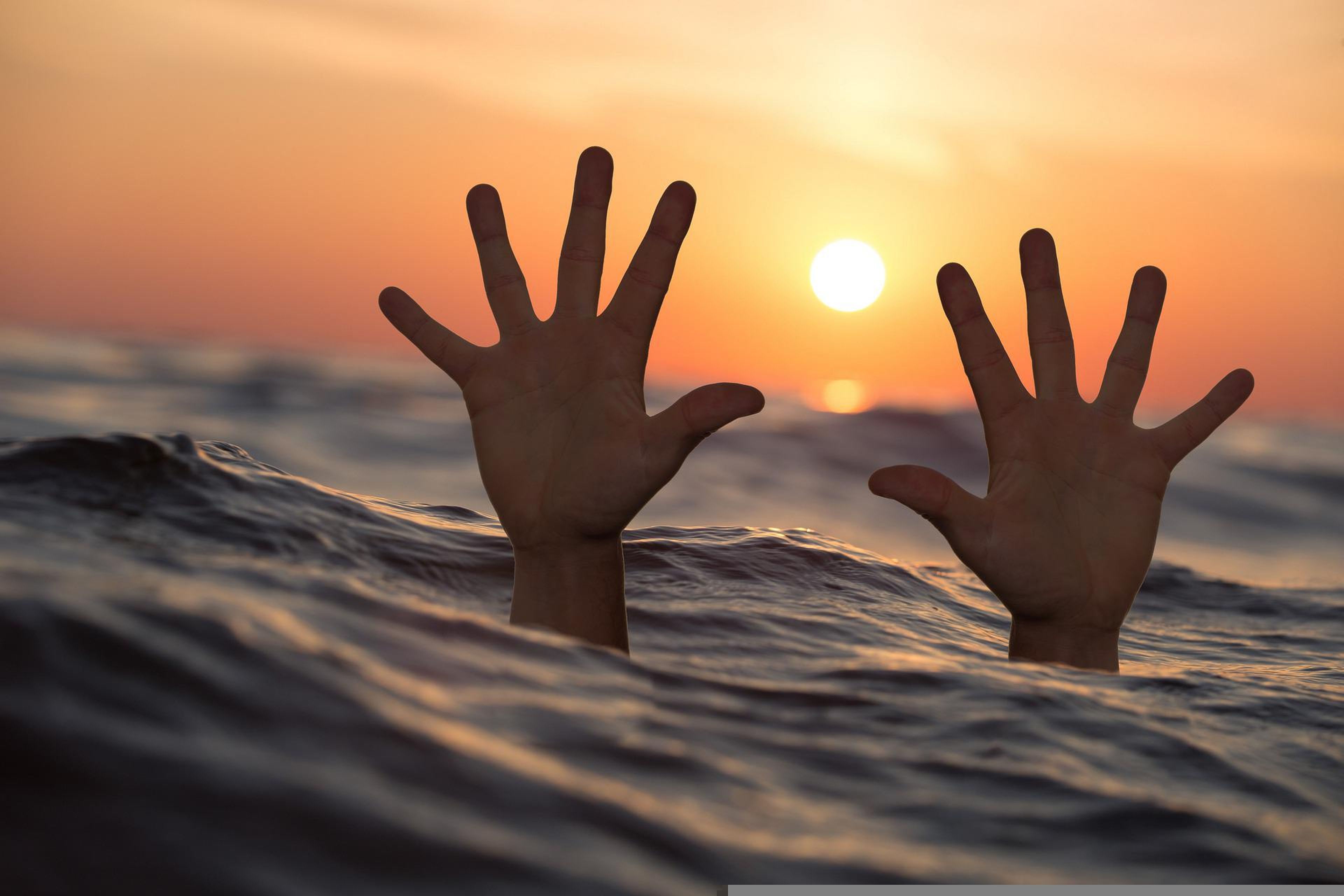 Las manos de una persona en el mar.