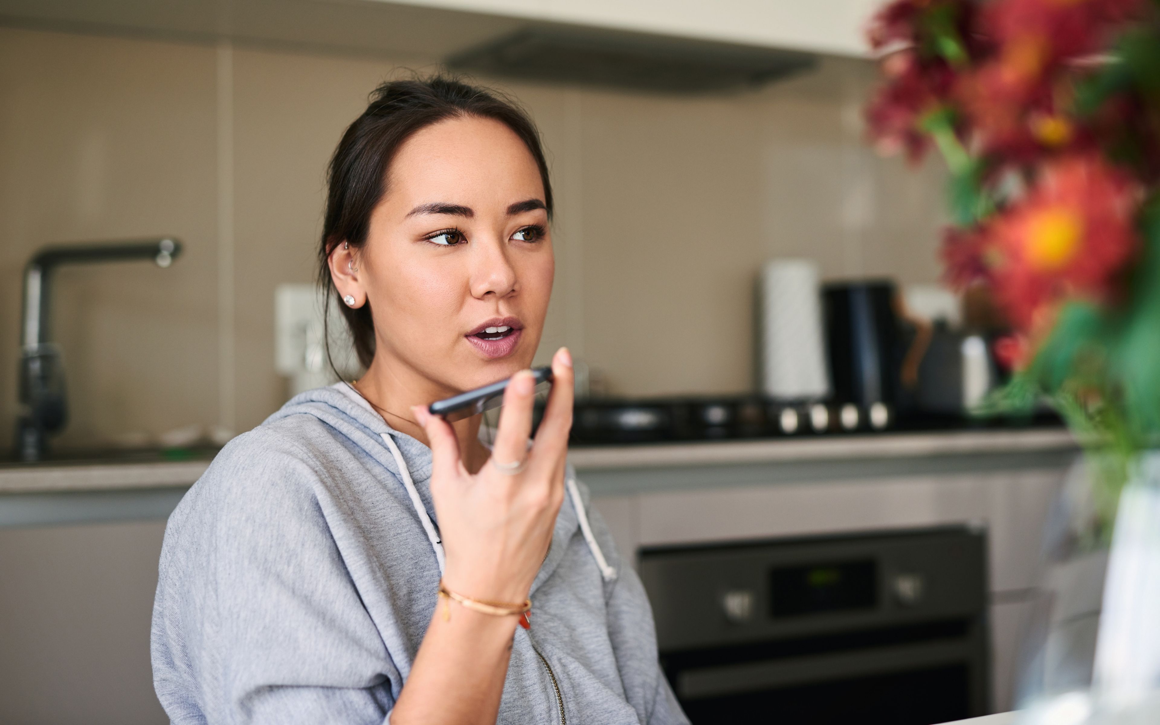 Una mujer habla con su asistente virtual en el móvil.