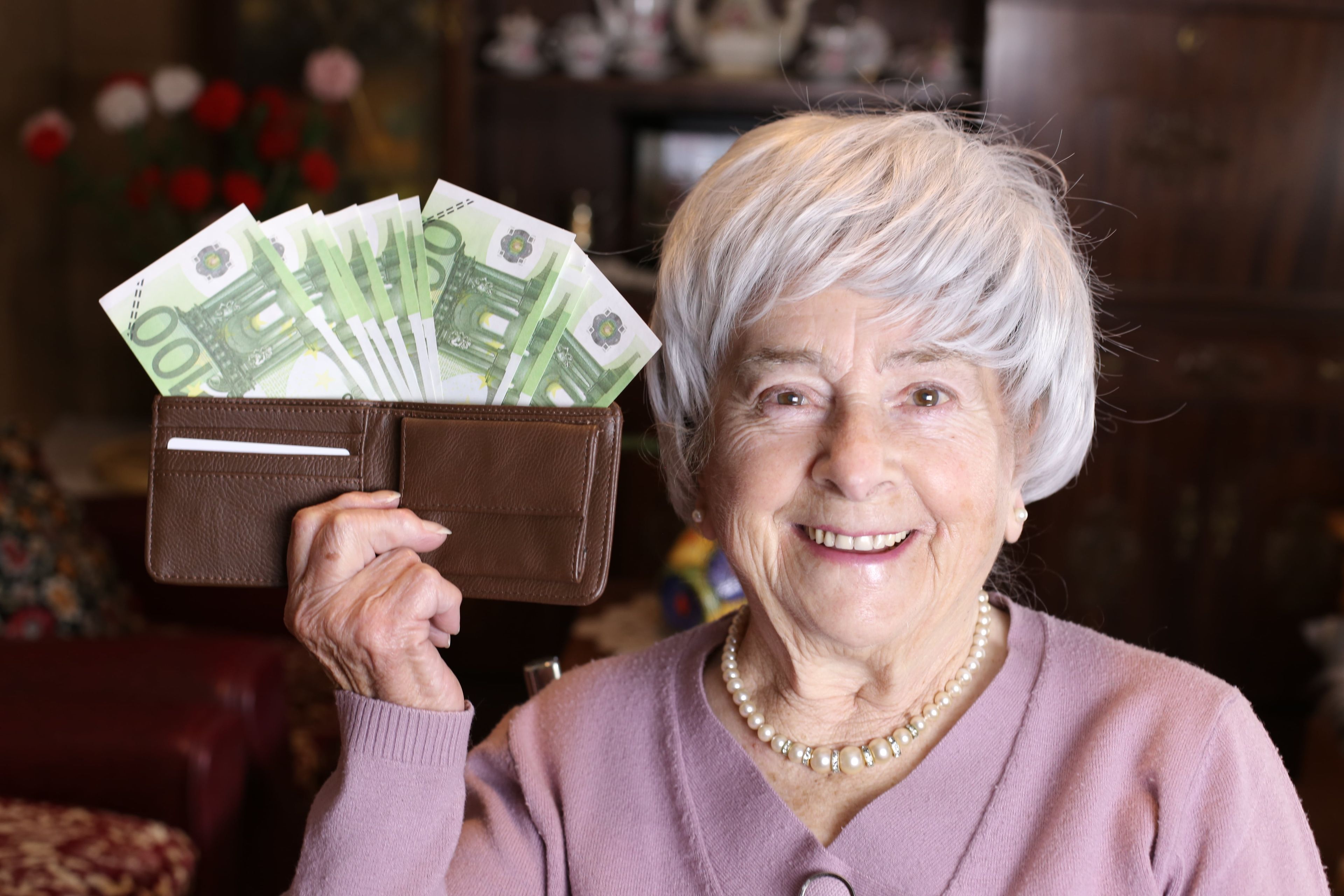 Una mujer mayor con billetes de 100 euros