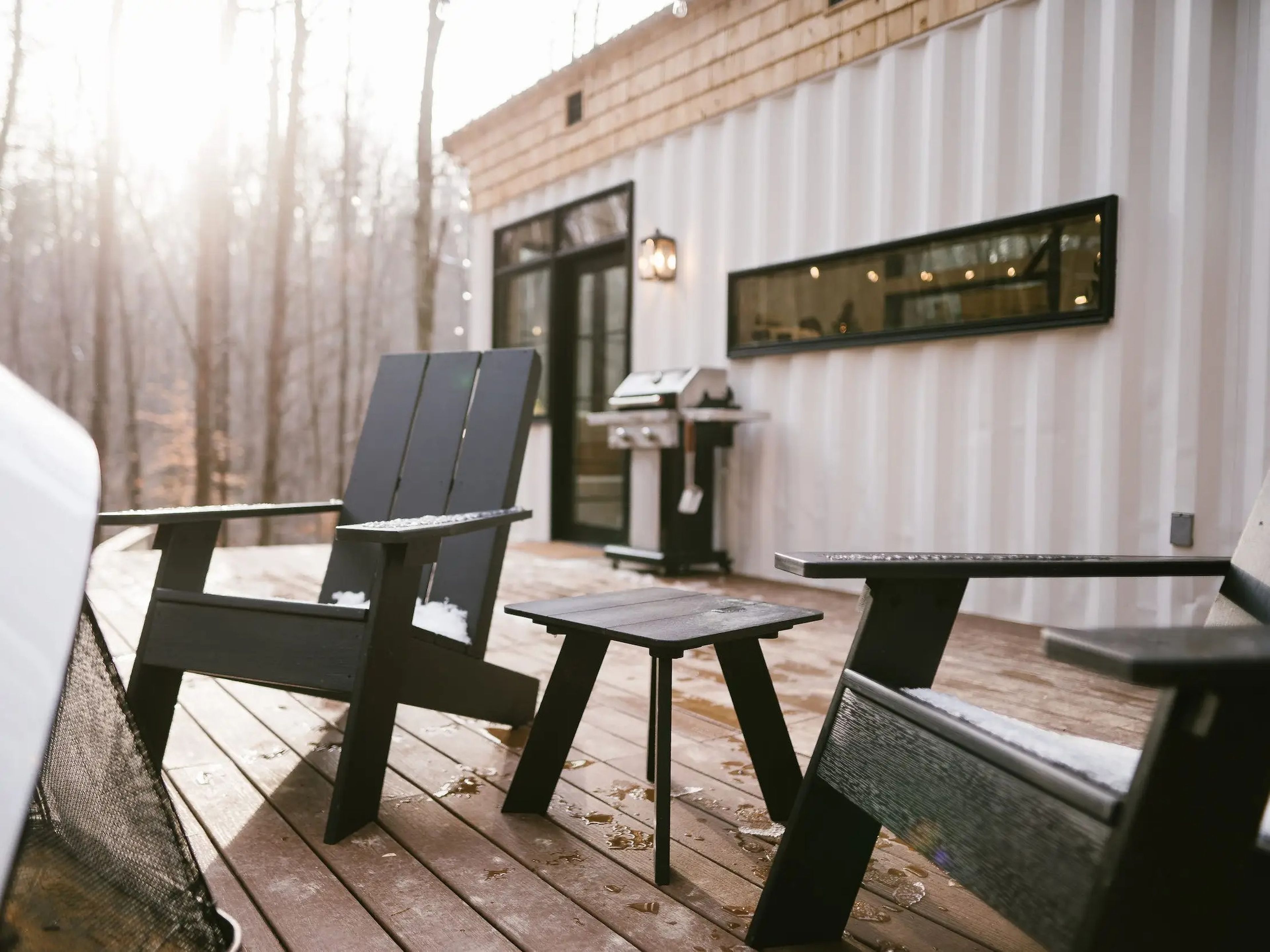 An outdoor deck with chairs at a shipping container home.
