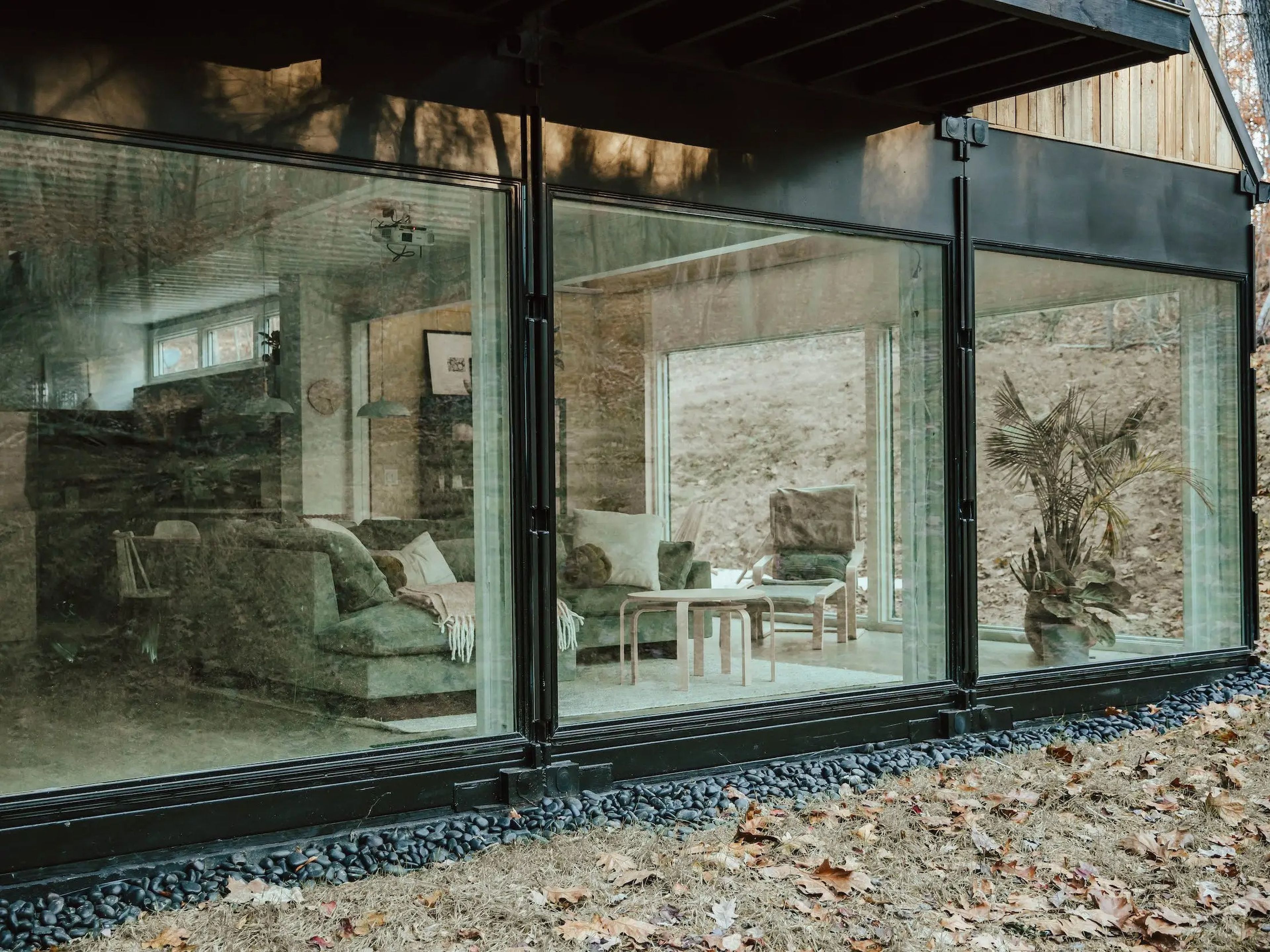 A wall of windows with a living room inside