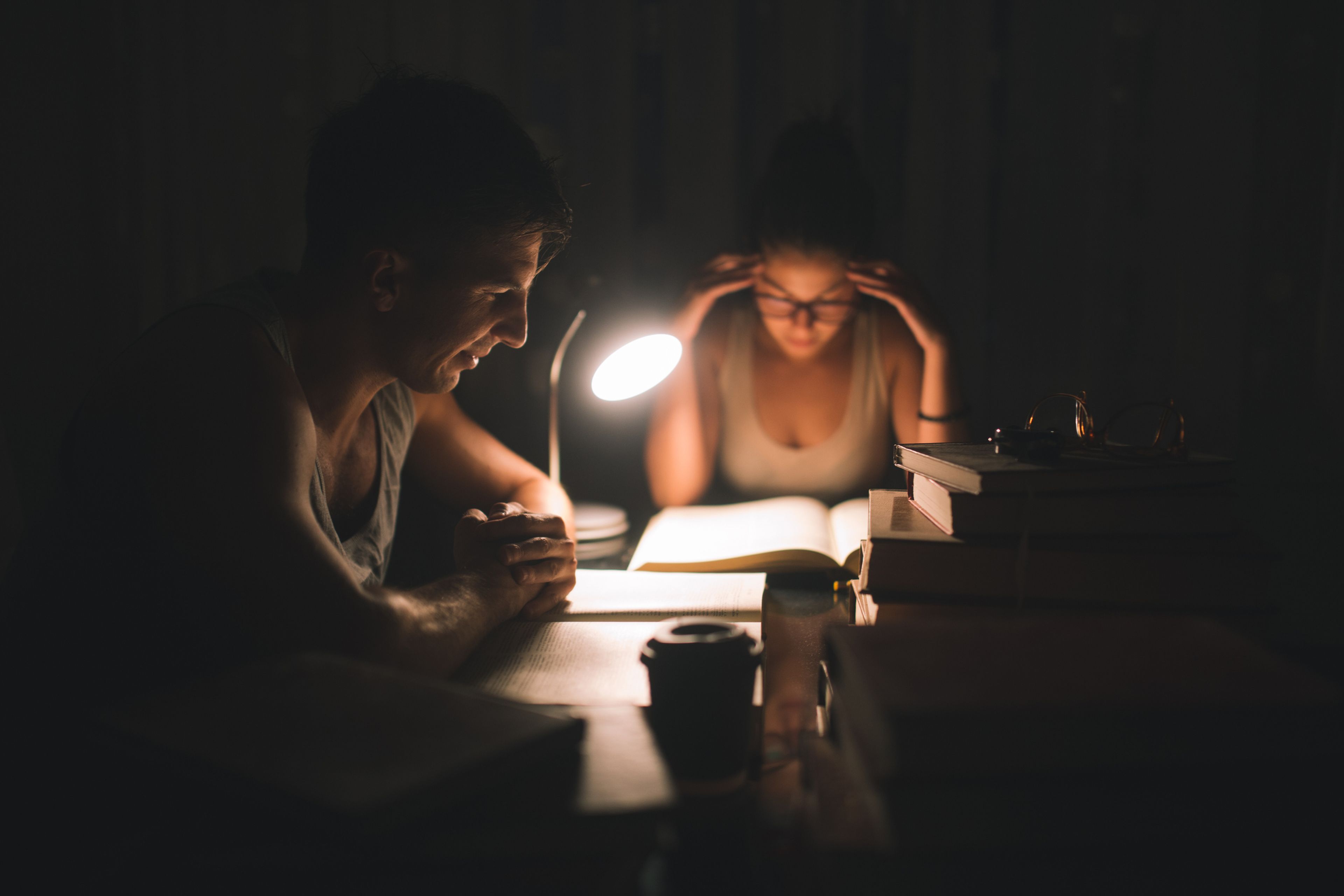 2 personas estudian bajo la luz del flexo.