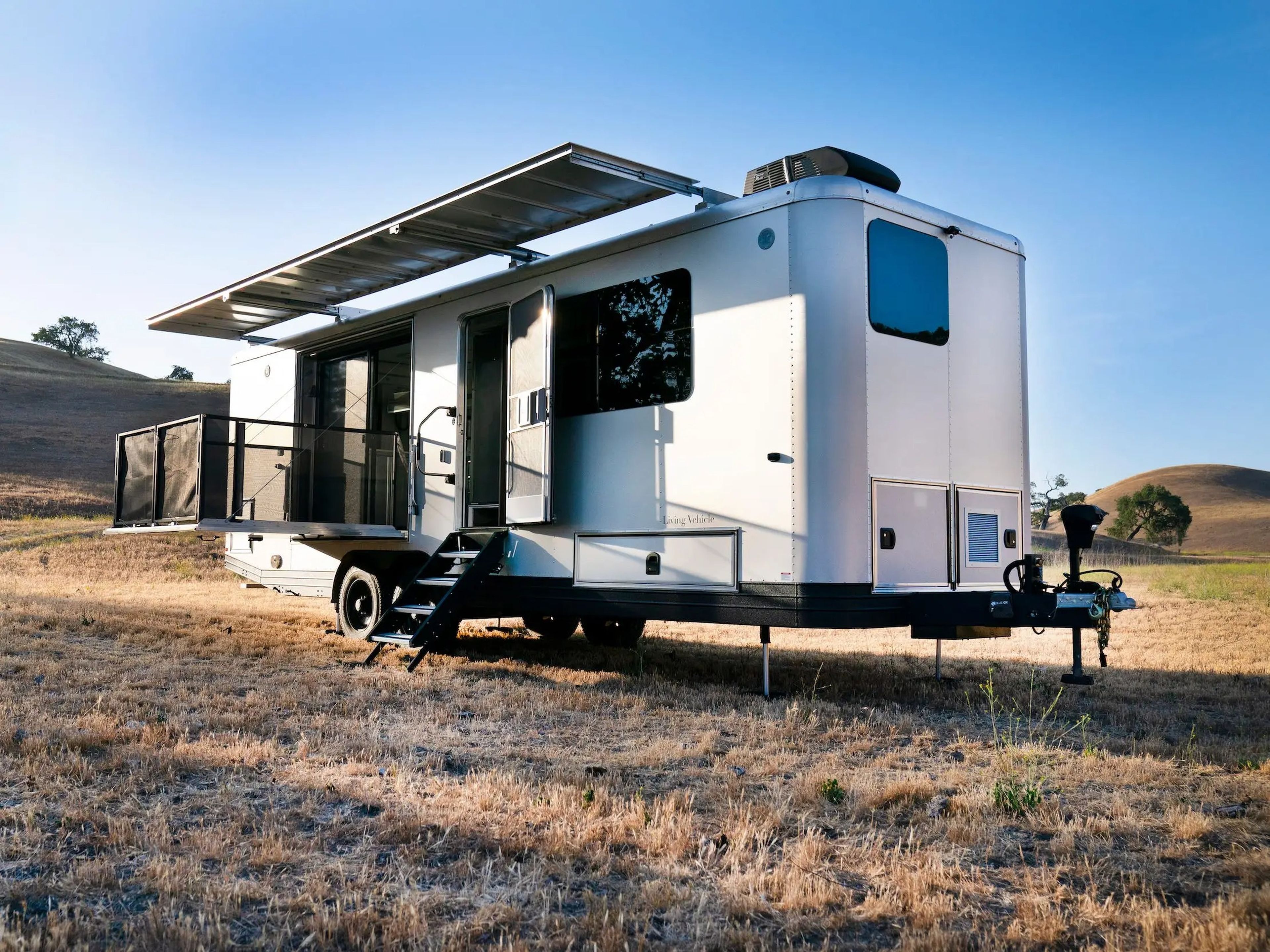 The exterior of the travel trailer as it sits on a brown field.