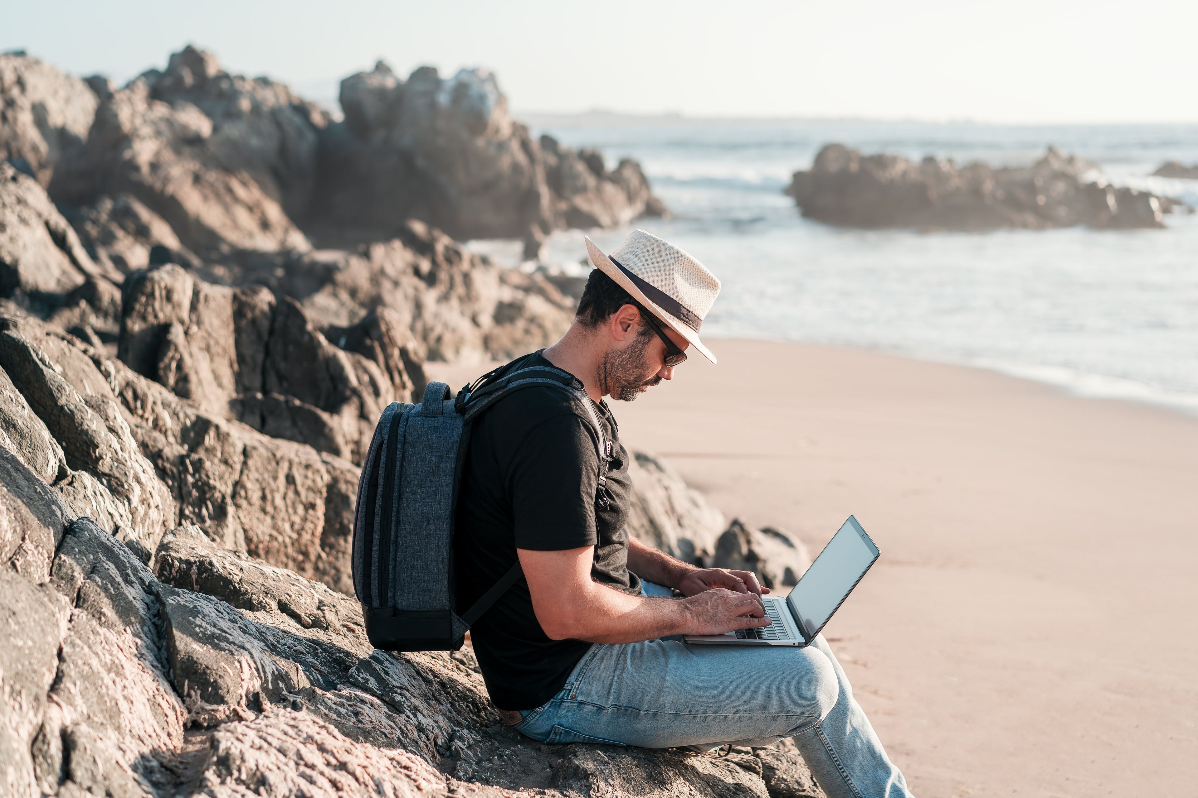 Un hombre con el ordenador en la playa