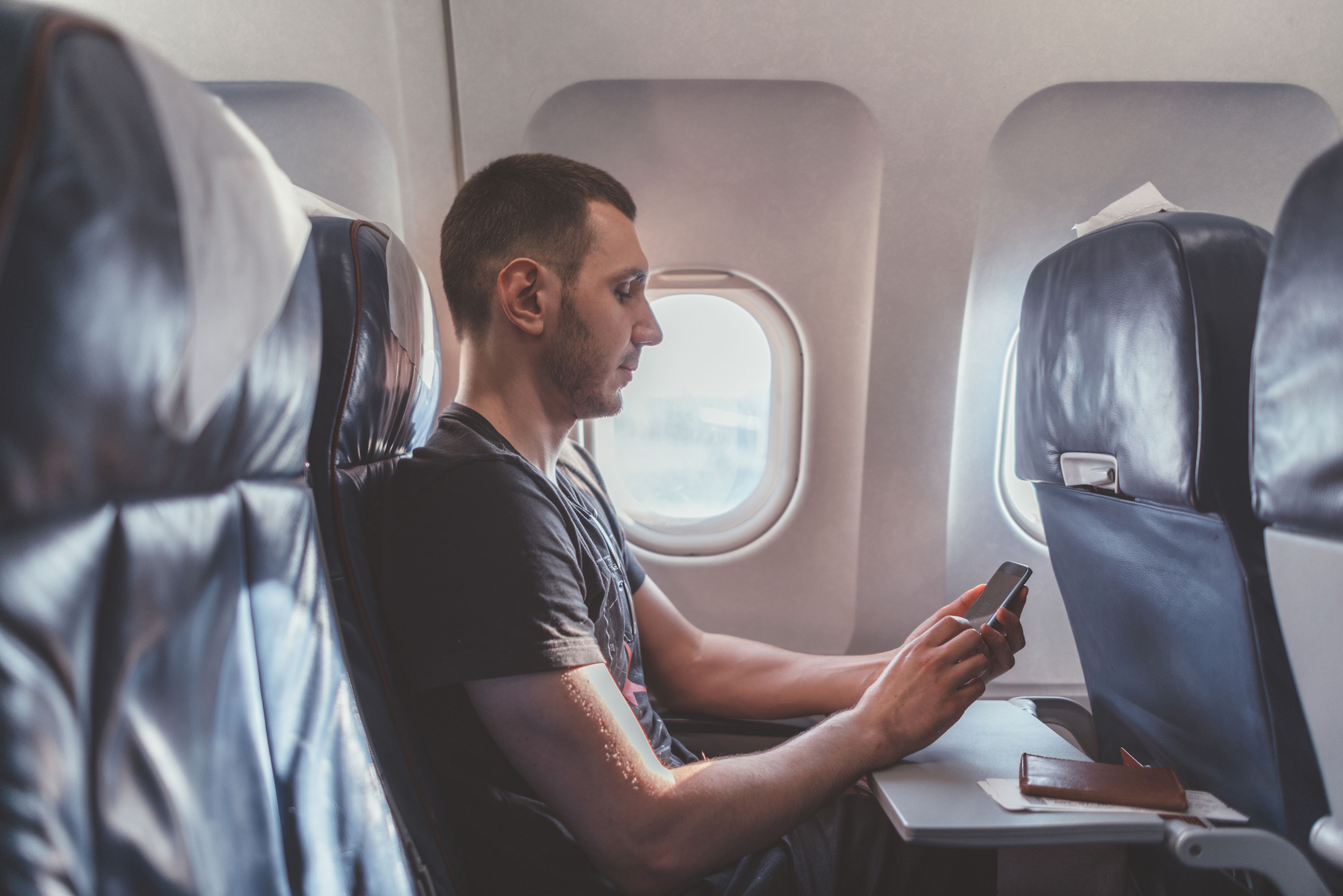 Hombre sentado en el asiento de la ventanilla del avión