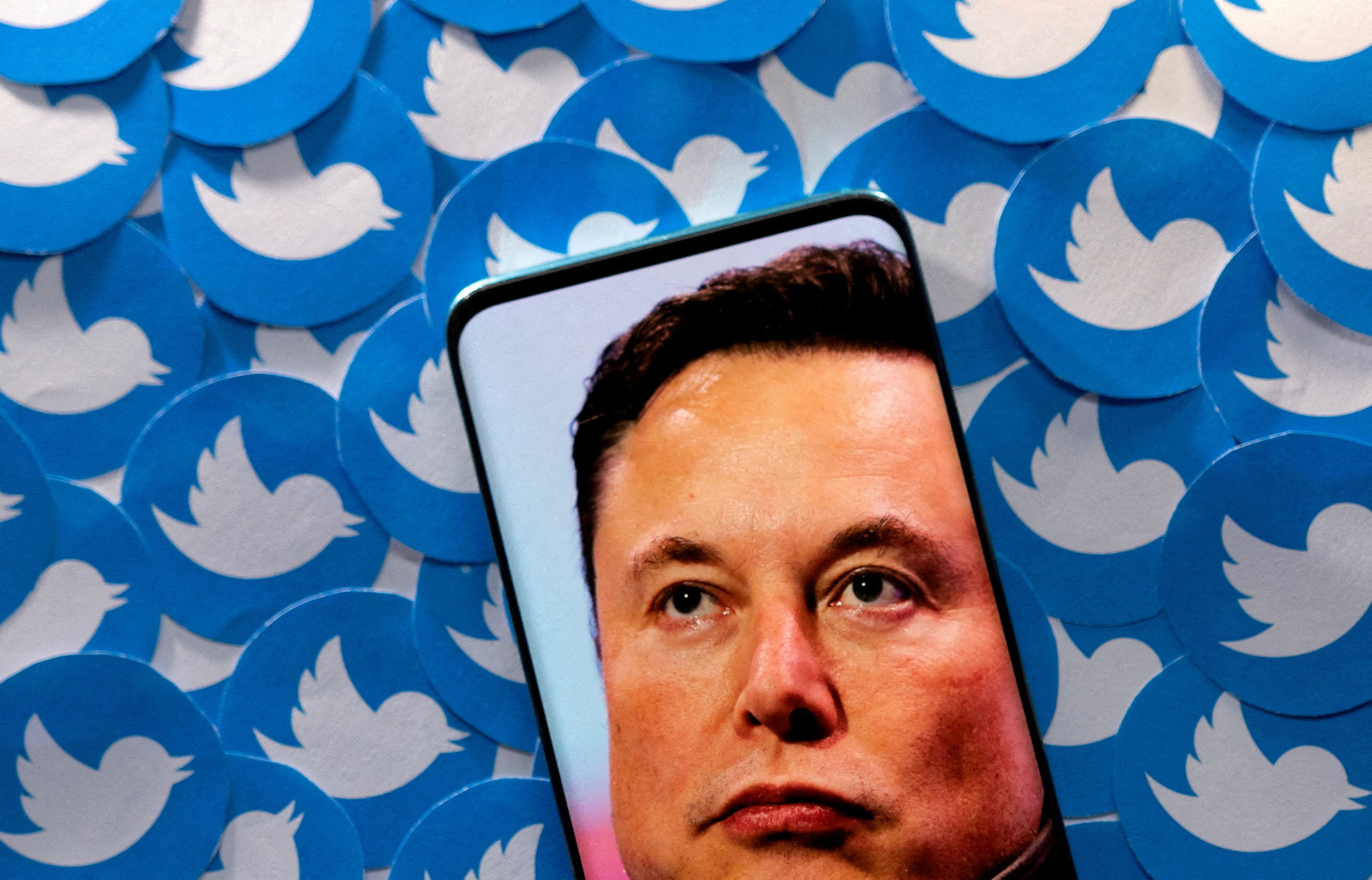 Ilustración con la cara de Elon Musk en un teléfono y símbolos de Twitter.