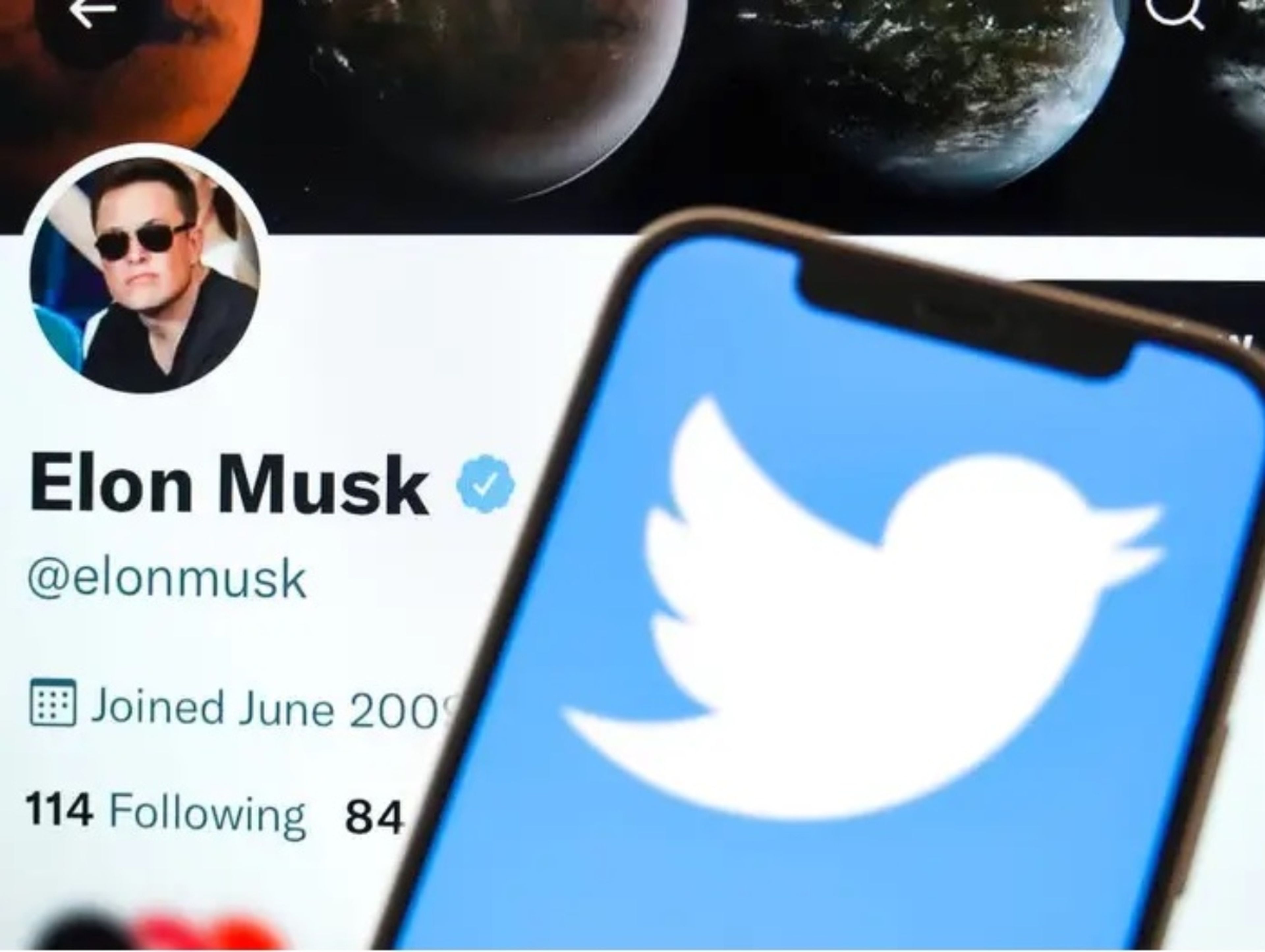 En esta ilustración fotográfica, el logotipo de Twitter se muestra en la pantalla del teléfono, con la cuenta de Twitter de Elon Musk de fondo.