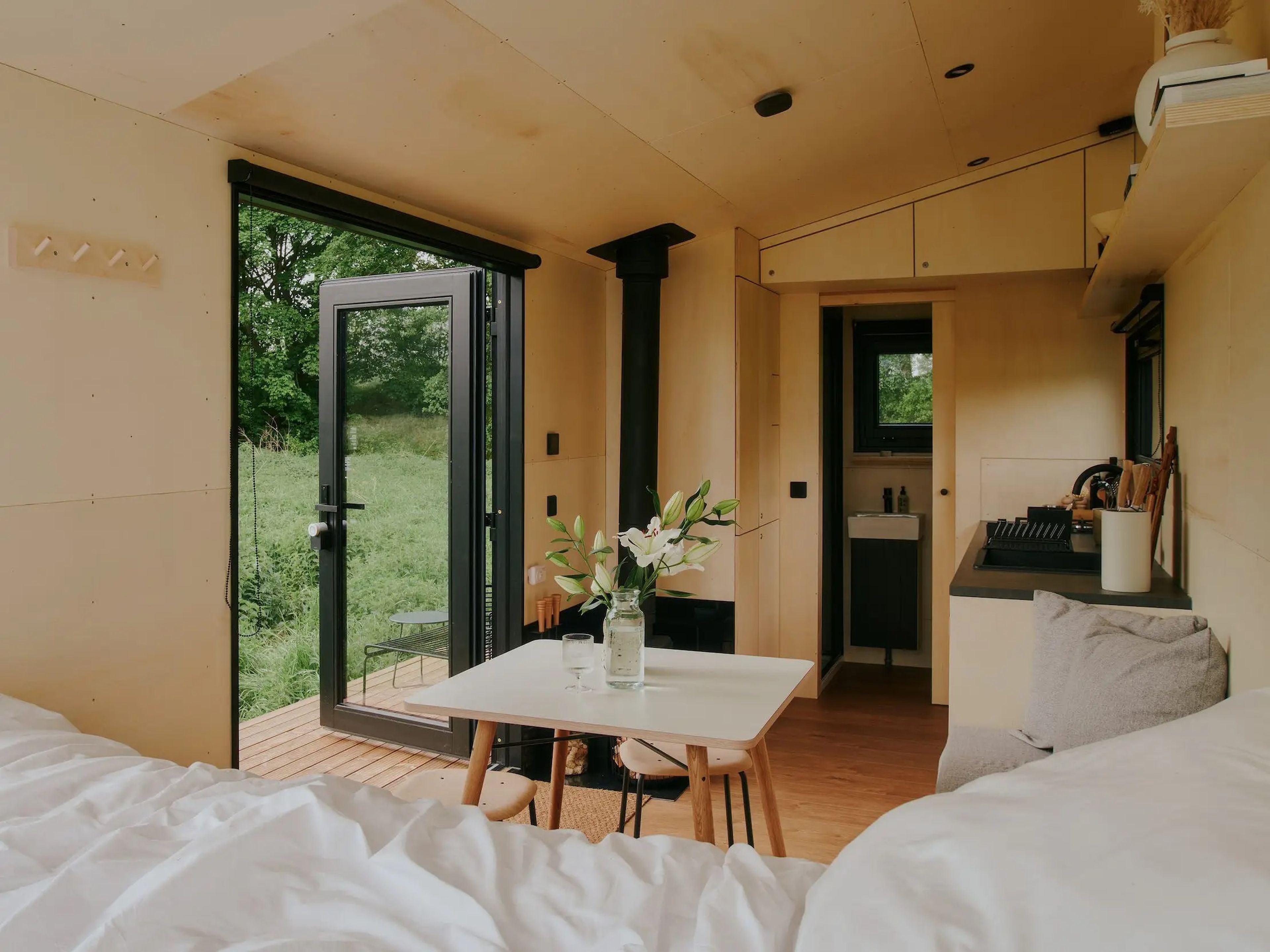 Estas cabañas tienen cama, mesa de comedor, cocina un baño y ventanas con vistas al campo.