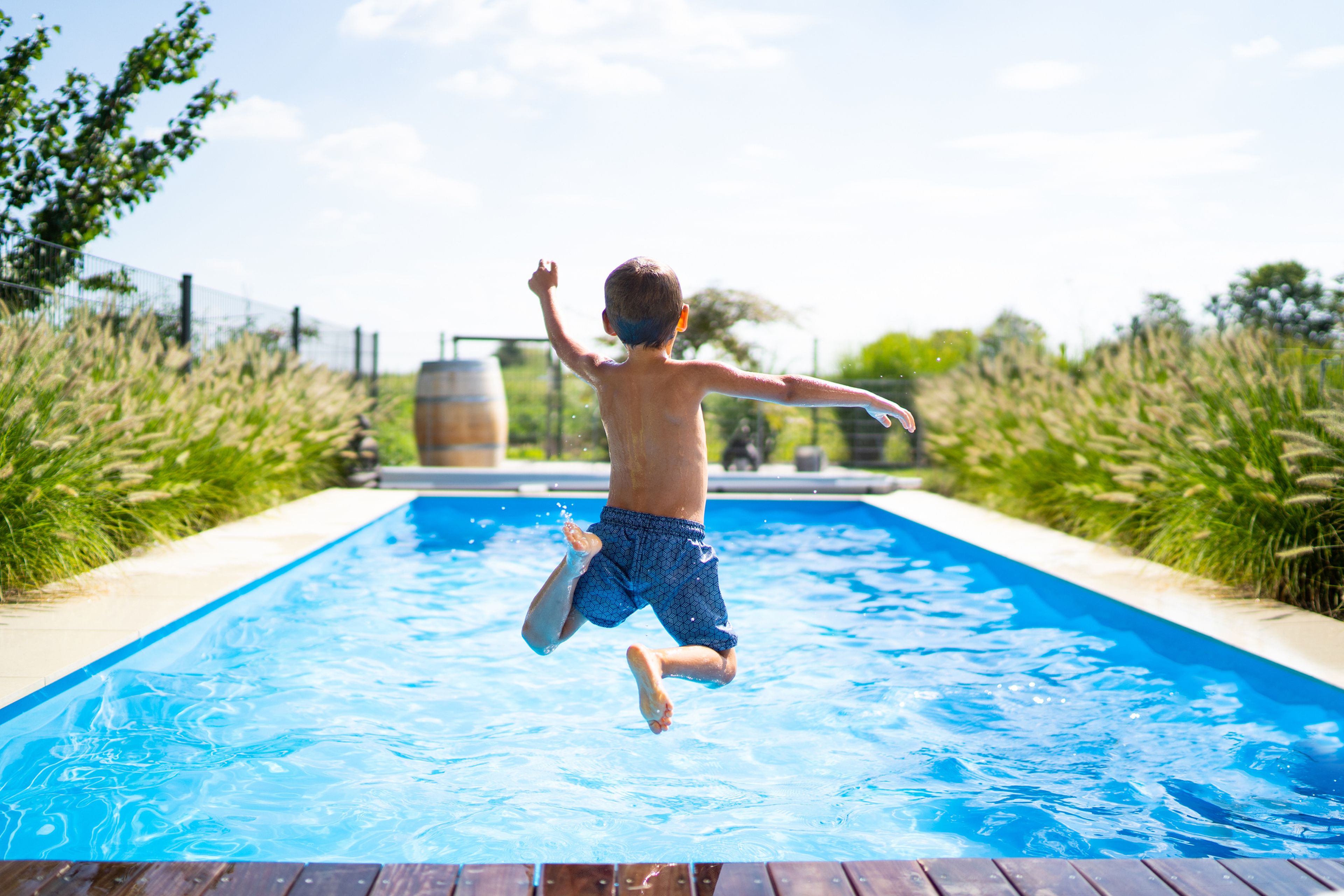 Niño saltando en la piscina solo