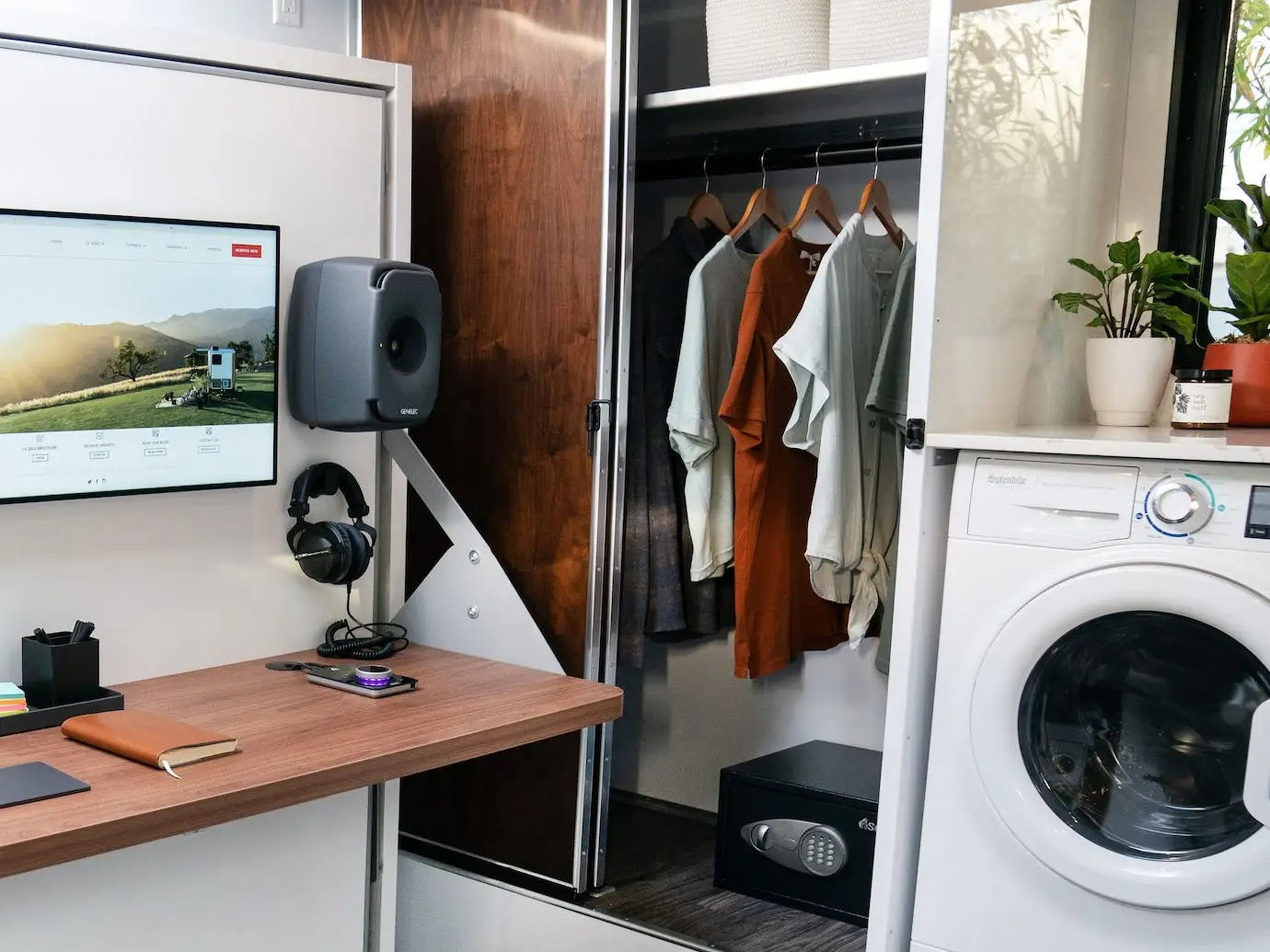 An office space with Apple products like a laptop next to a washer, closet.
