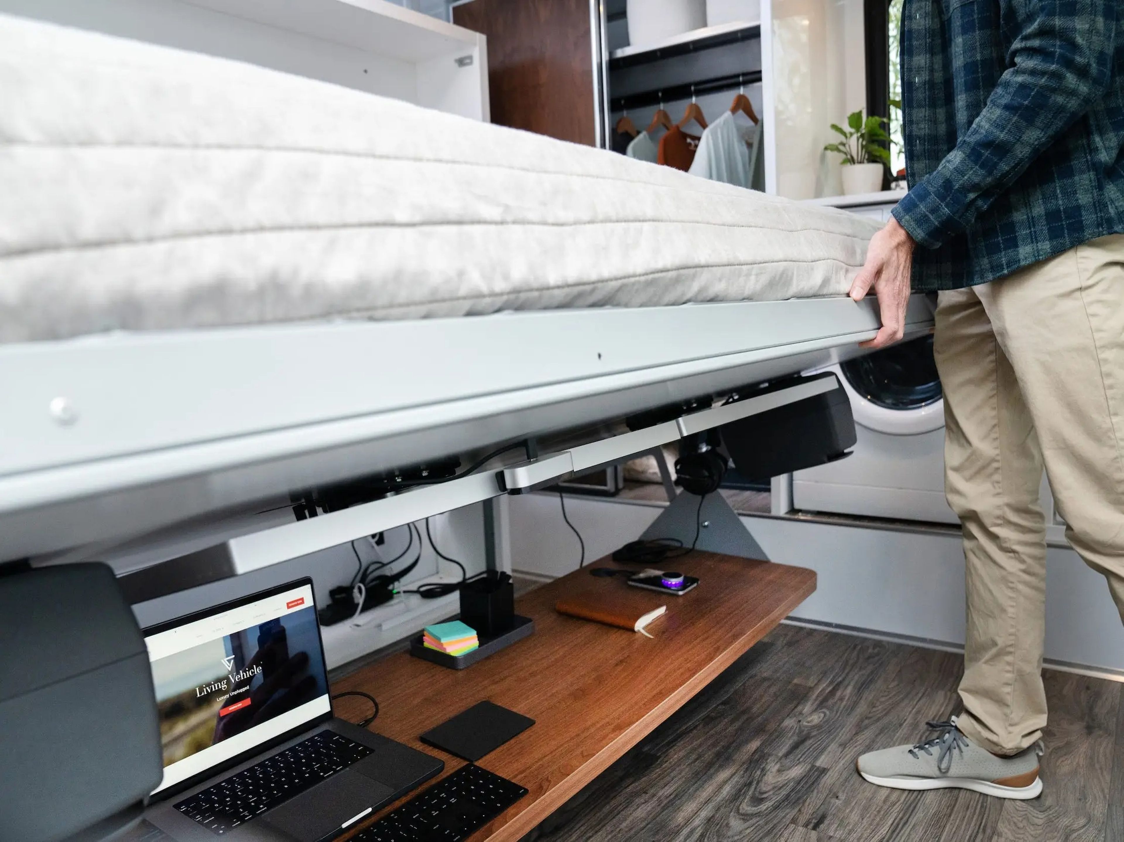 A person lifting a mattress to unveil a desk