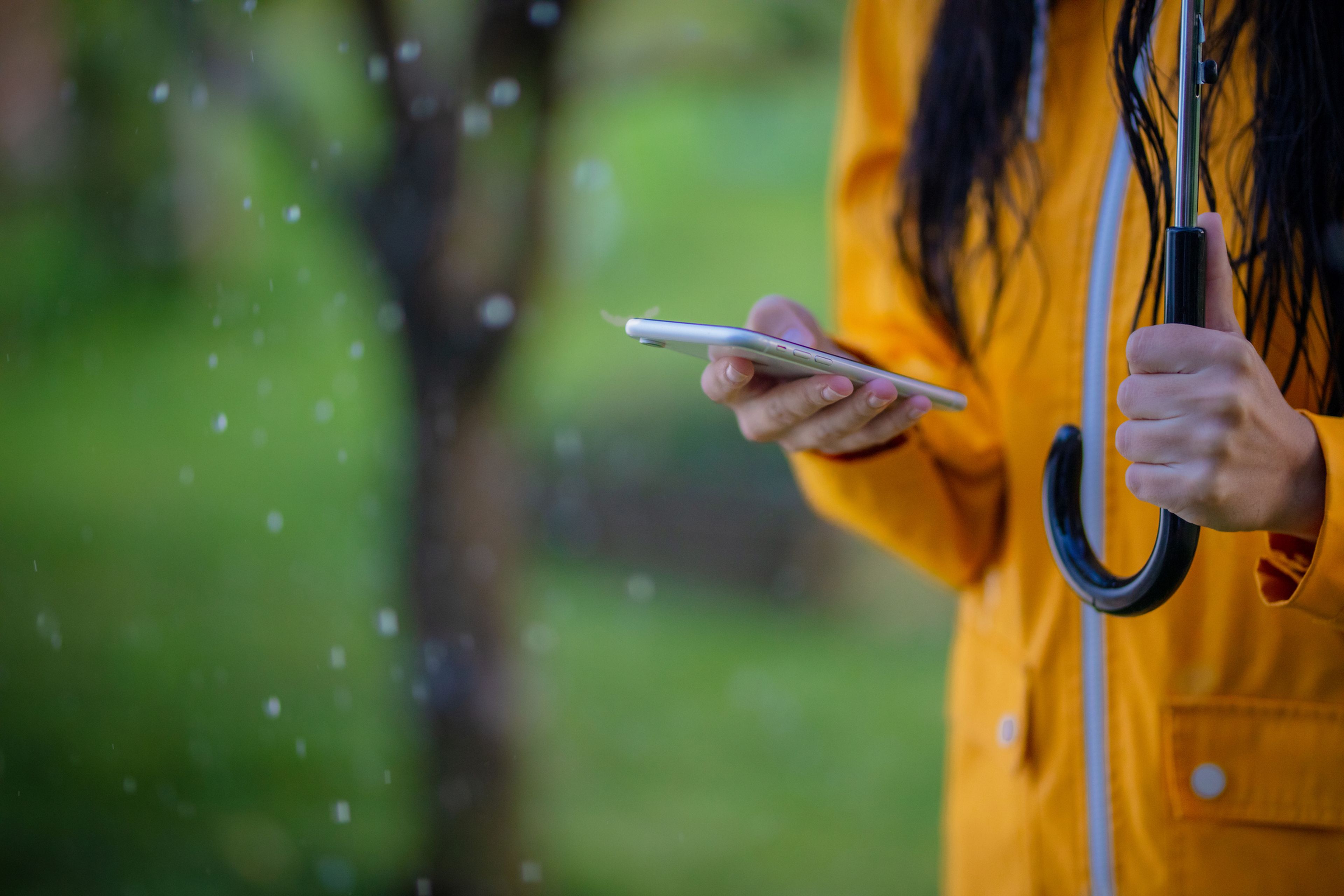 Una persona usando el móvil bajo la lluvia