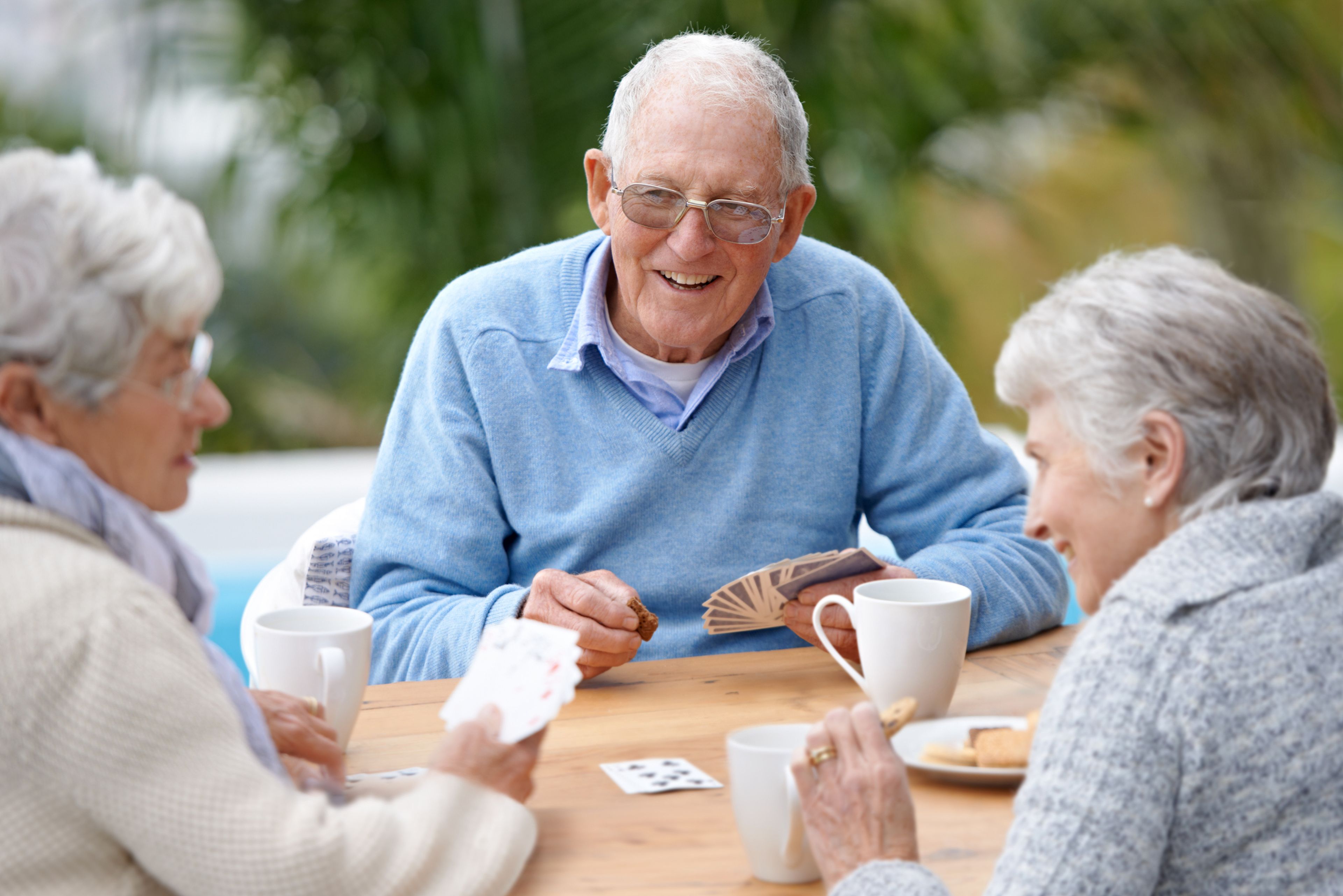 Personas mayores jugando a las cartas
