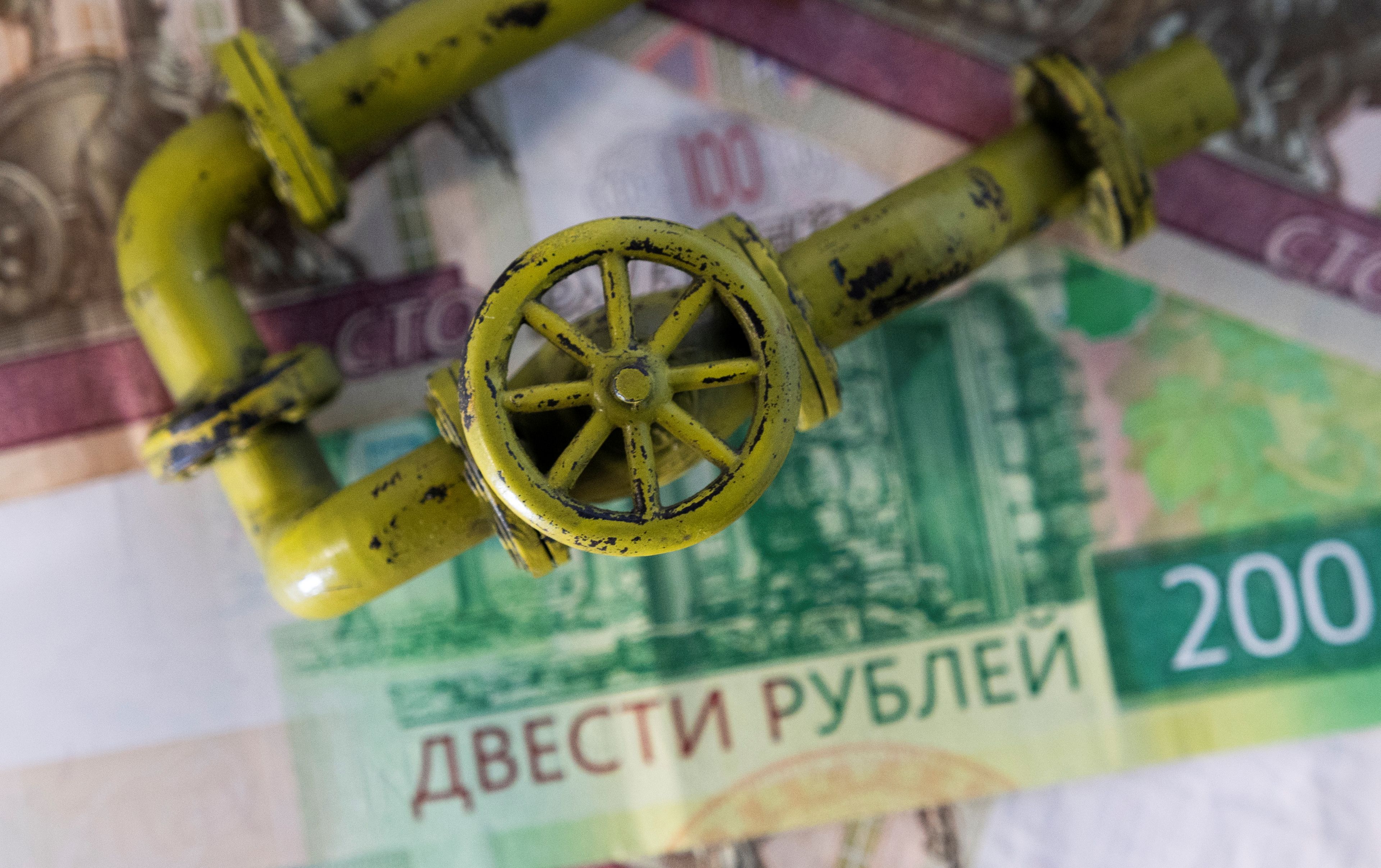 Una tubería de gas sobre unos billetes de rublos rusos.