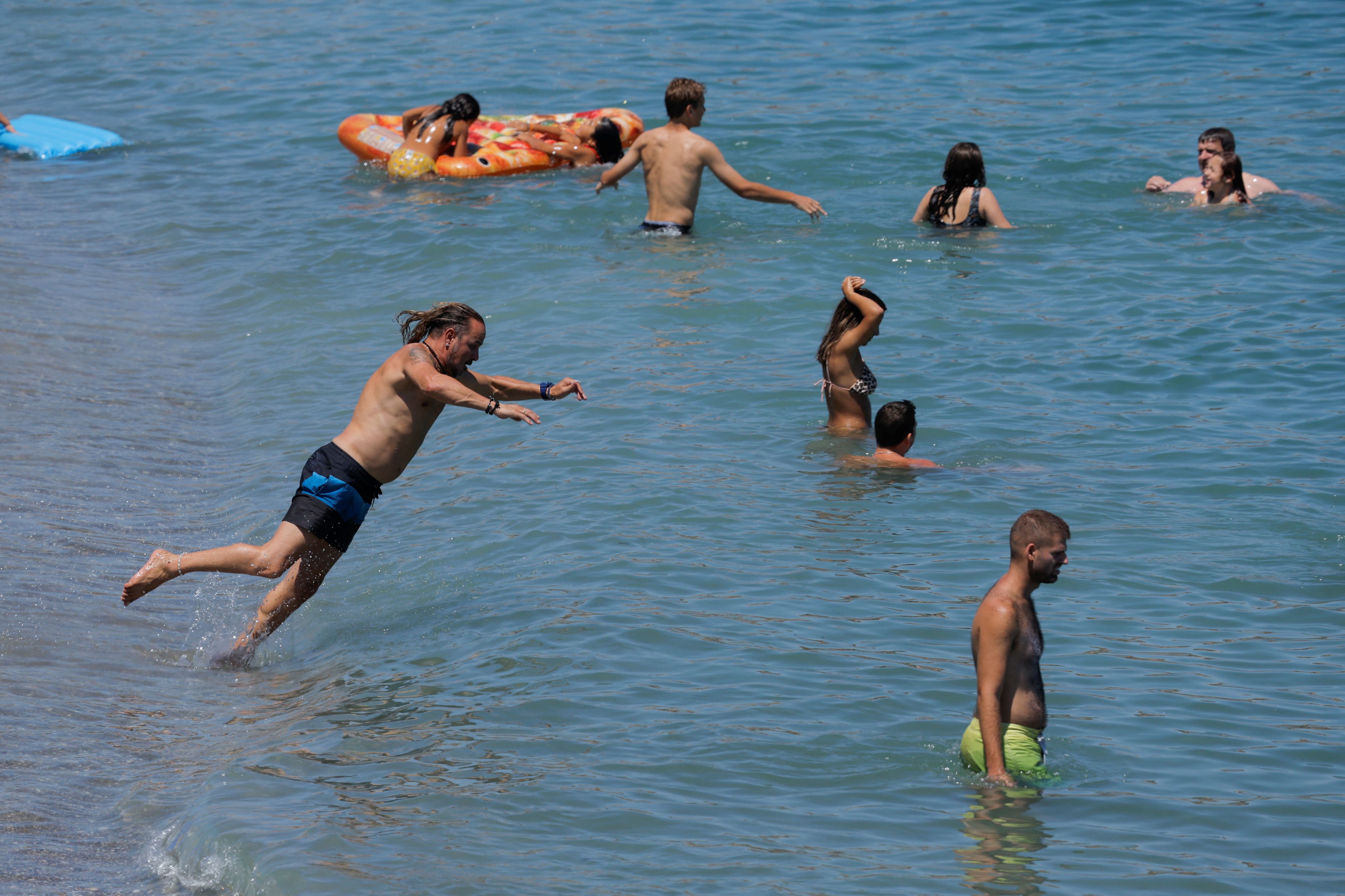 Varias personas en el mar, en Málaga (España): playa, ola de calor
