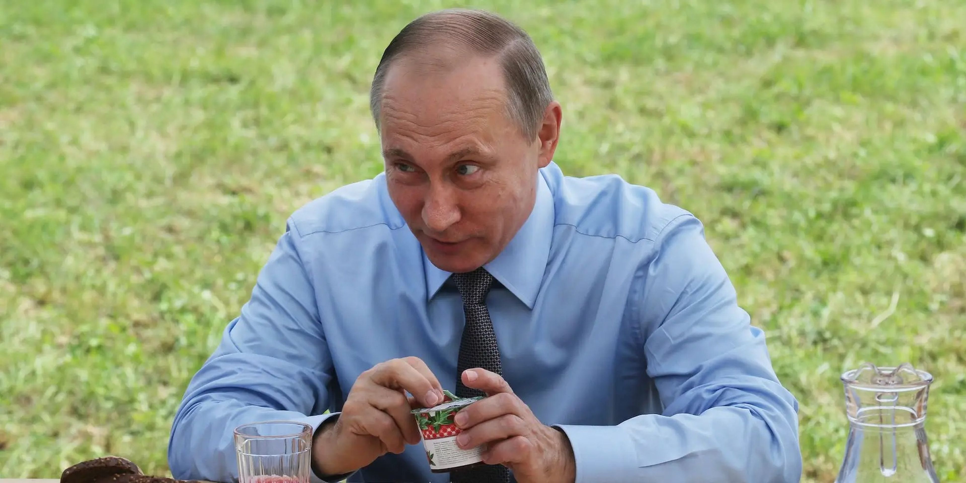 Vladimir Putin sentado en una mesa llena de comida