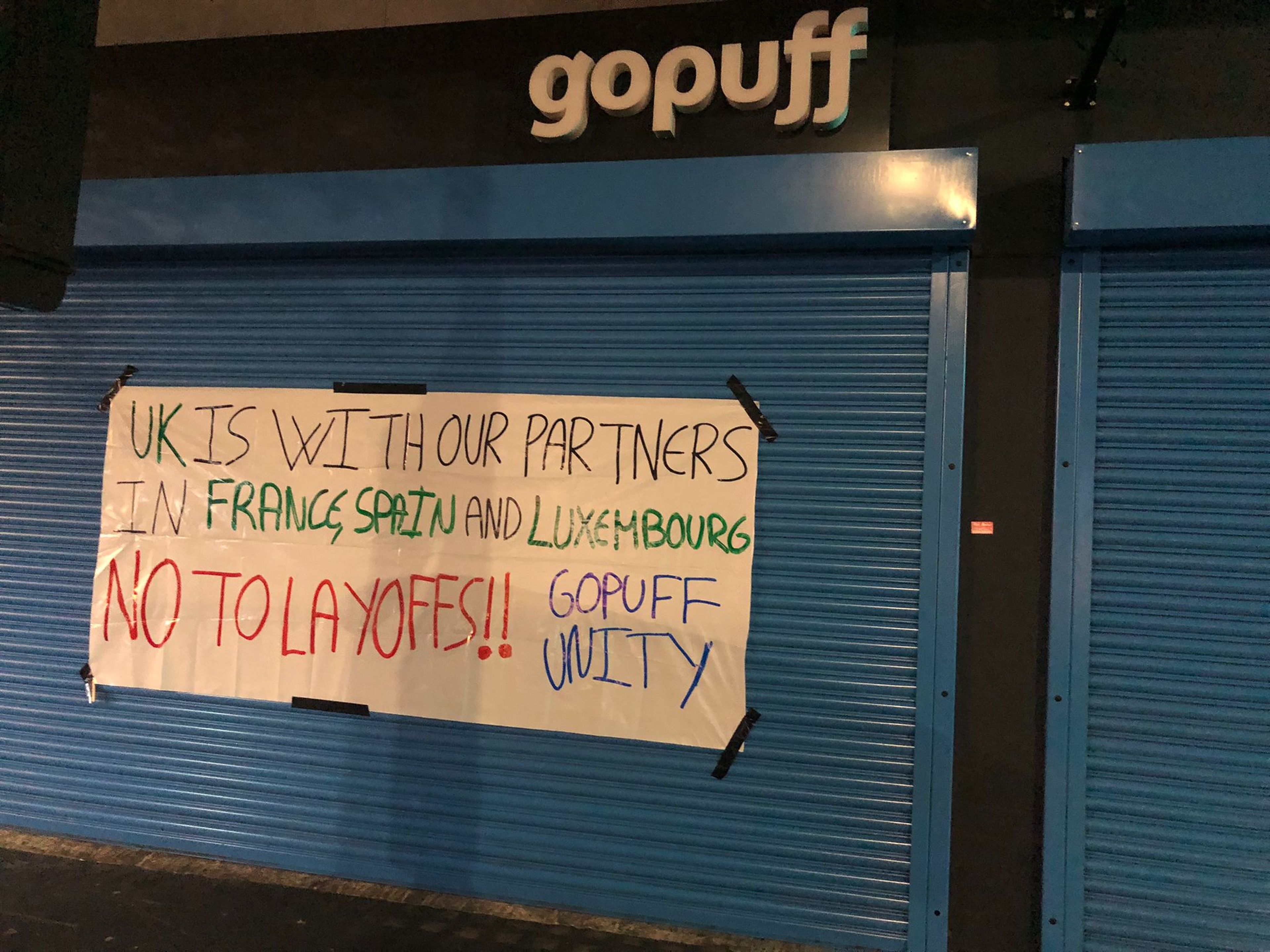 Una pancarta en una tienda de Gopuff de Londres muestra un mensaje de solidaridad con los compañeros de España. "No a los despidos", se puede leer.