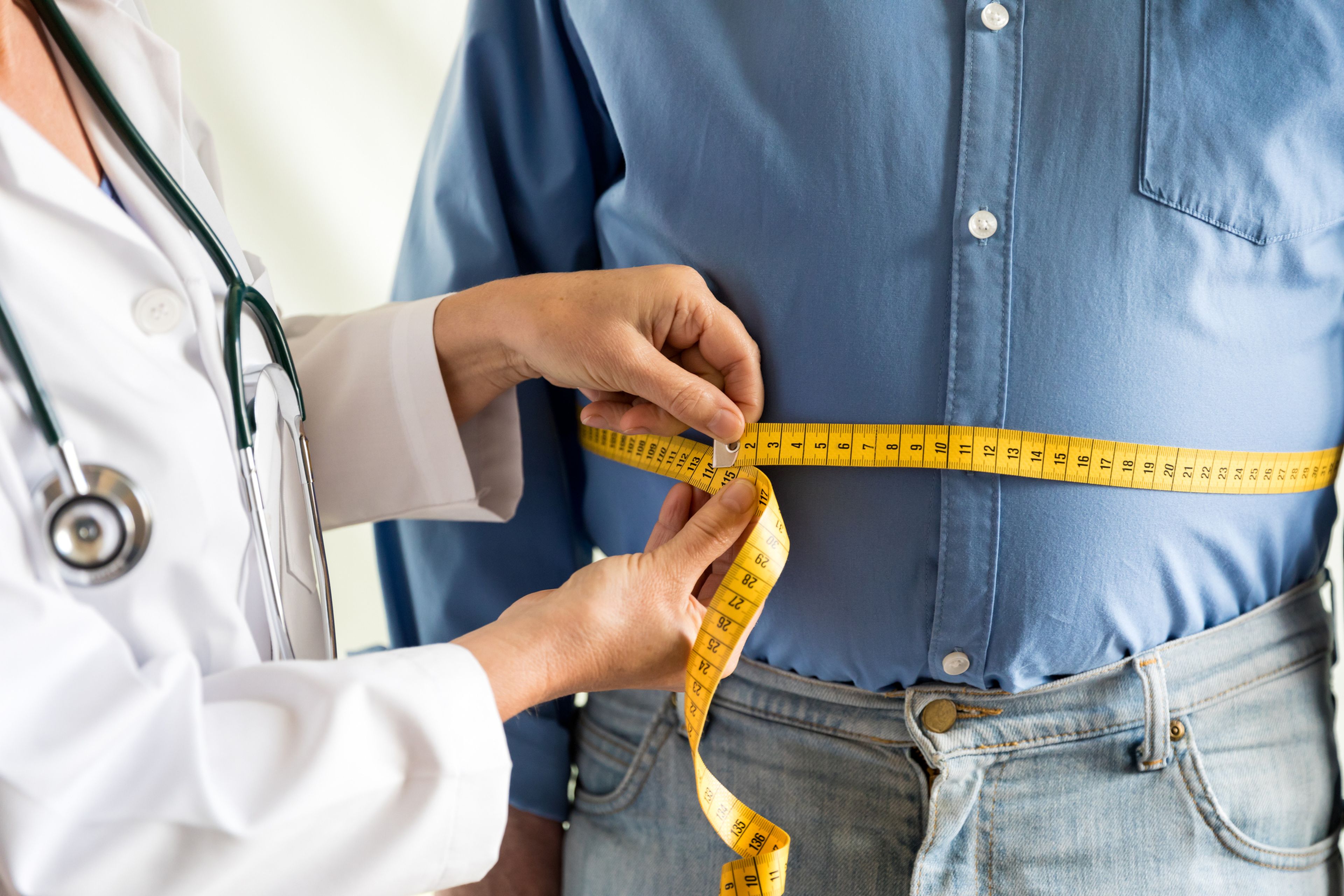 Medico midiendo la cintura a un hombre