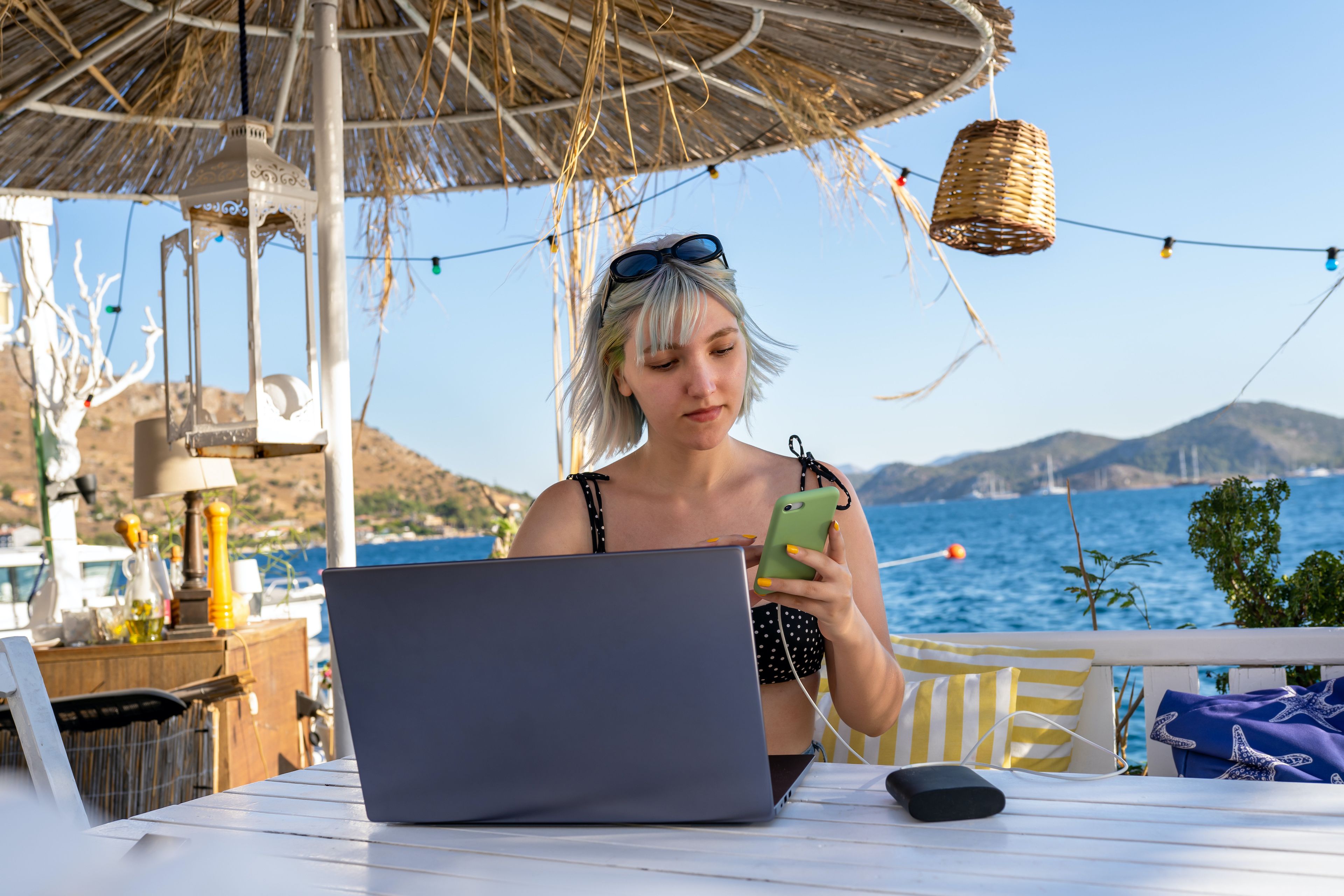 Mujer trabaja en la playa con el ordenador.
