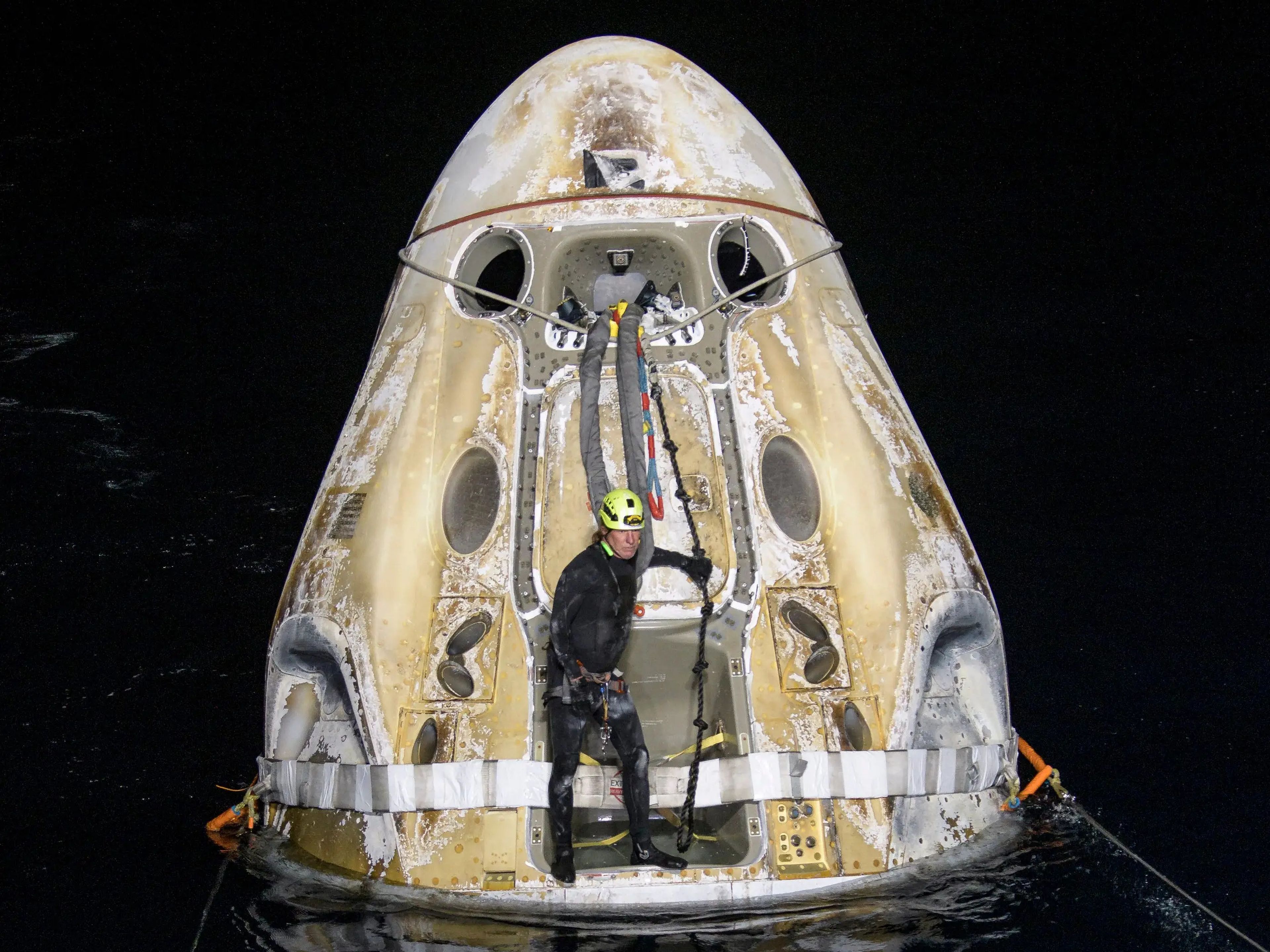 Los equipos de apoyo trabajan en torno a la nave espacial Crew Dragon Resilience de SpaceX poco después de que amerizara con astronautas de la Estación Espacial Internacional, en mayo de 2021.