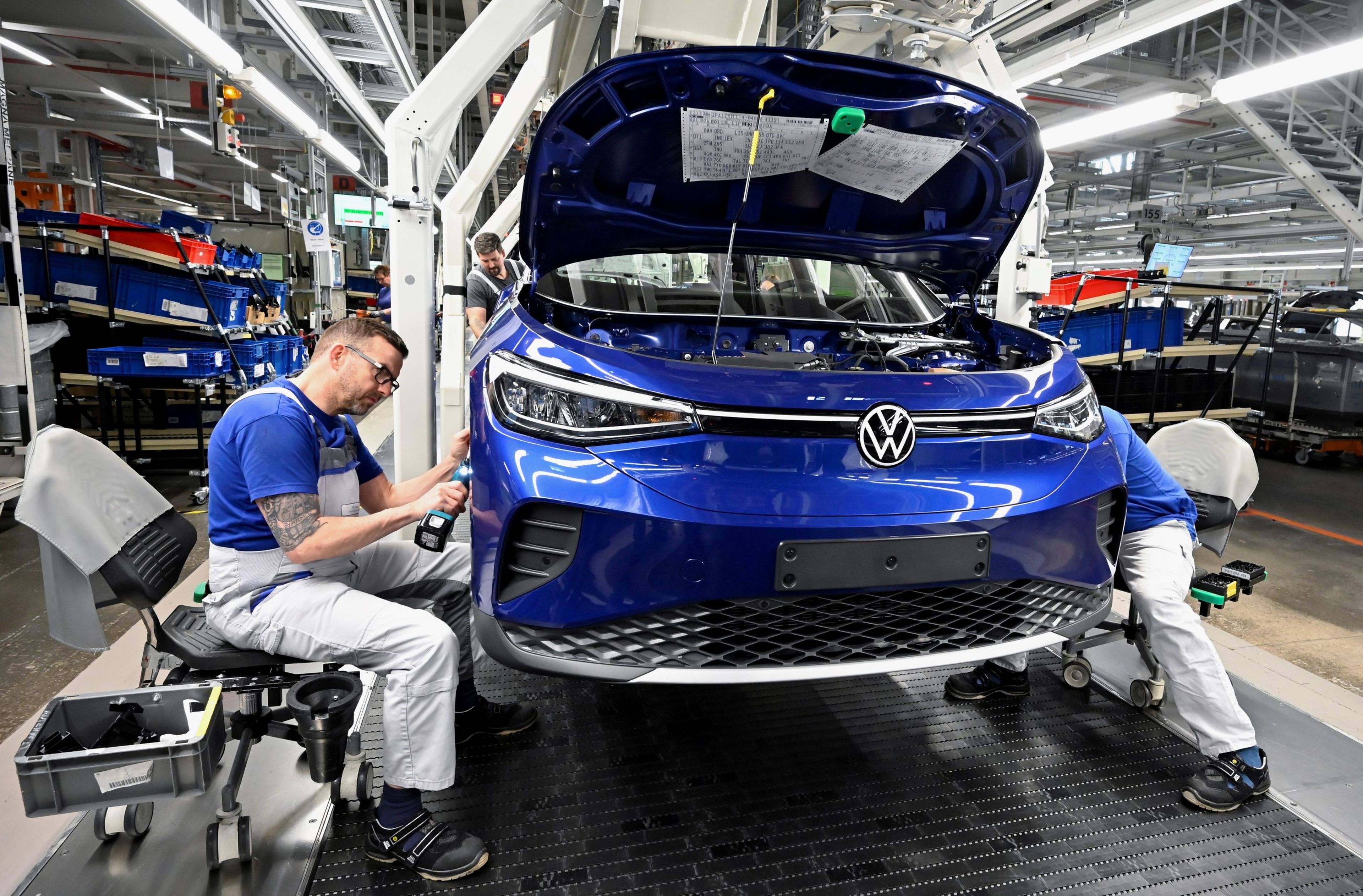 Técnicos trabajando en la línea de producción de modelos de coches eléctricos del Grupo Volkswagen