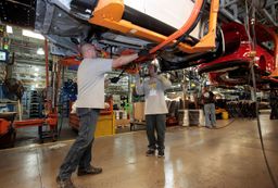 Los trabajadores de Ford instalan un cargador de baterías en vehículo Ford Focus Electric en la planta de ensamblaje de Michigan.