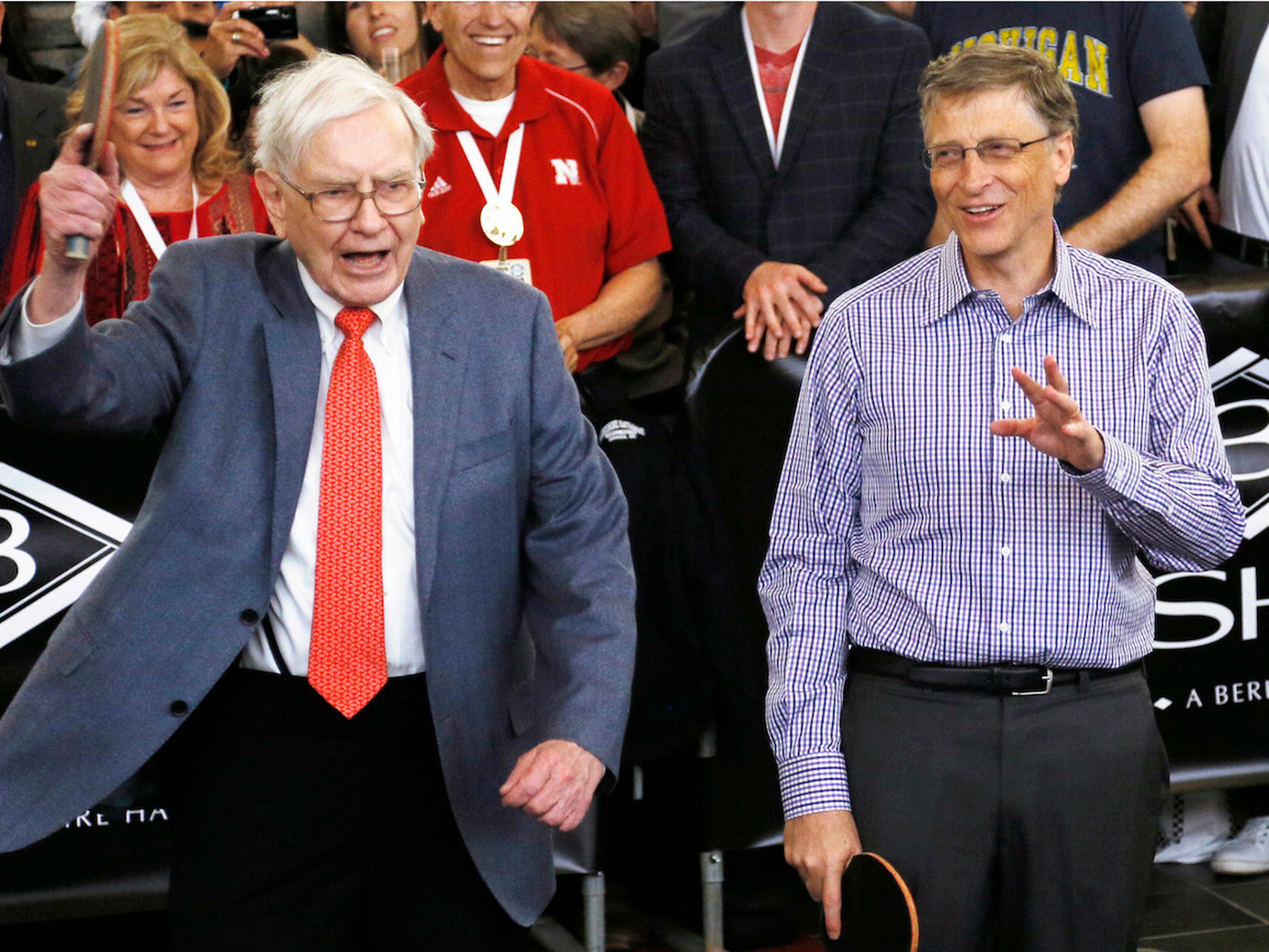 El CEO de Berkshire Hathaway, Warren Buffett (i), gesticula antes de un partido de ping pong con el presidente de Microsoft, Bill Gates.